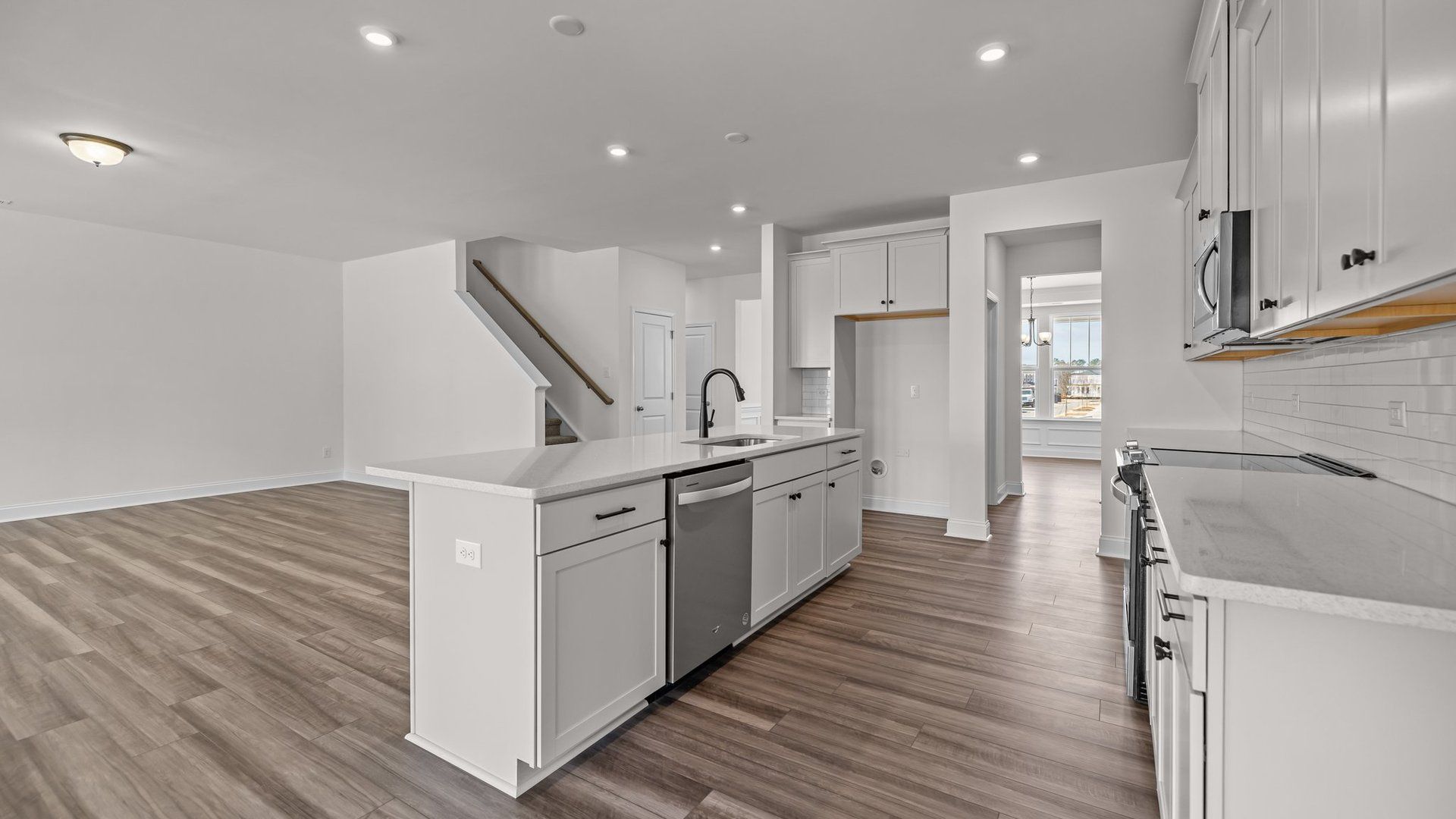 Open concept kitchen and family room with elevated ceiling and premium finishes, in the Norris Design by DRB Homes, York, SC