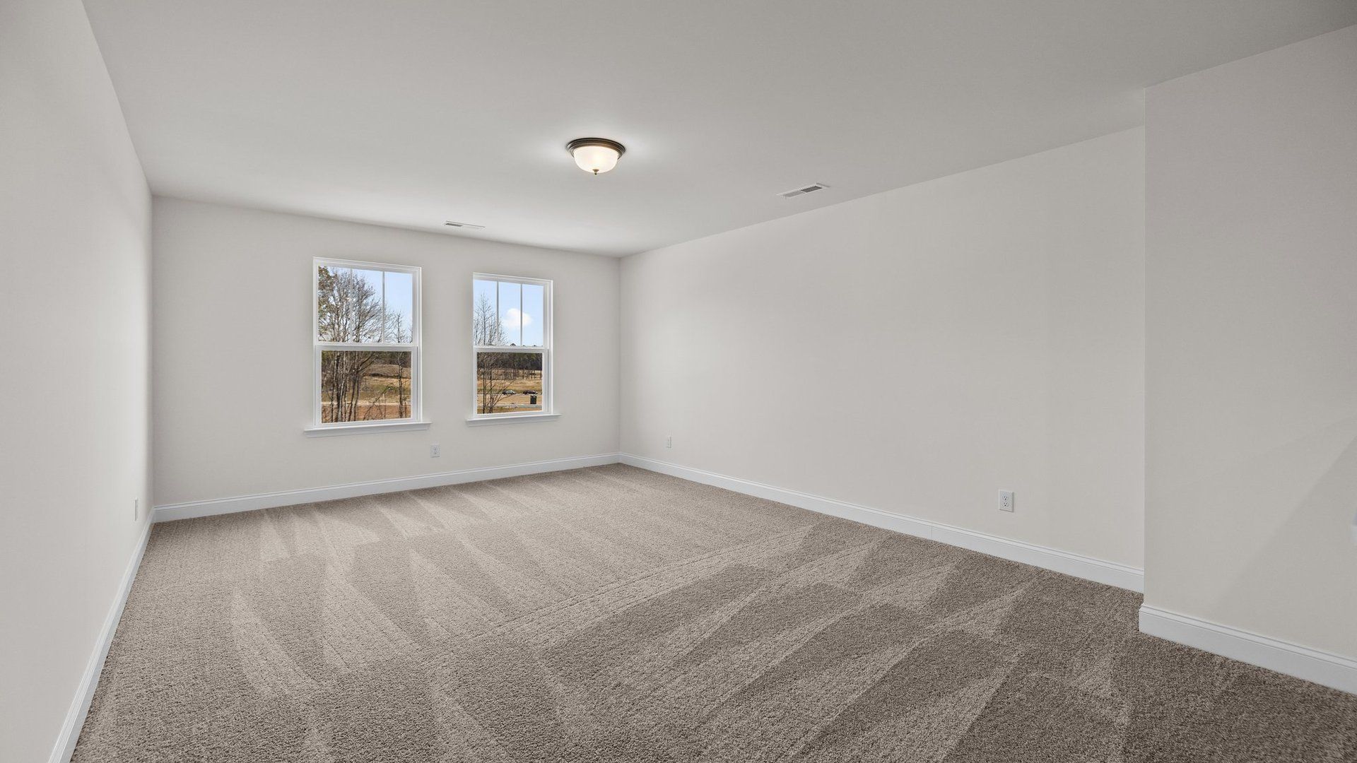 Spacious and bright secondary bedroom with elevated ceiling and large windows, in the Norris Design by DRB Homes in York, SC