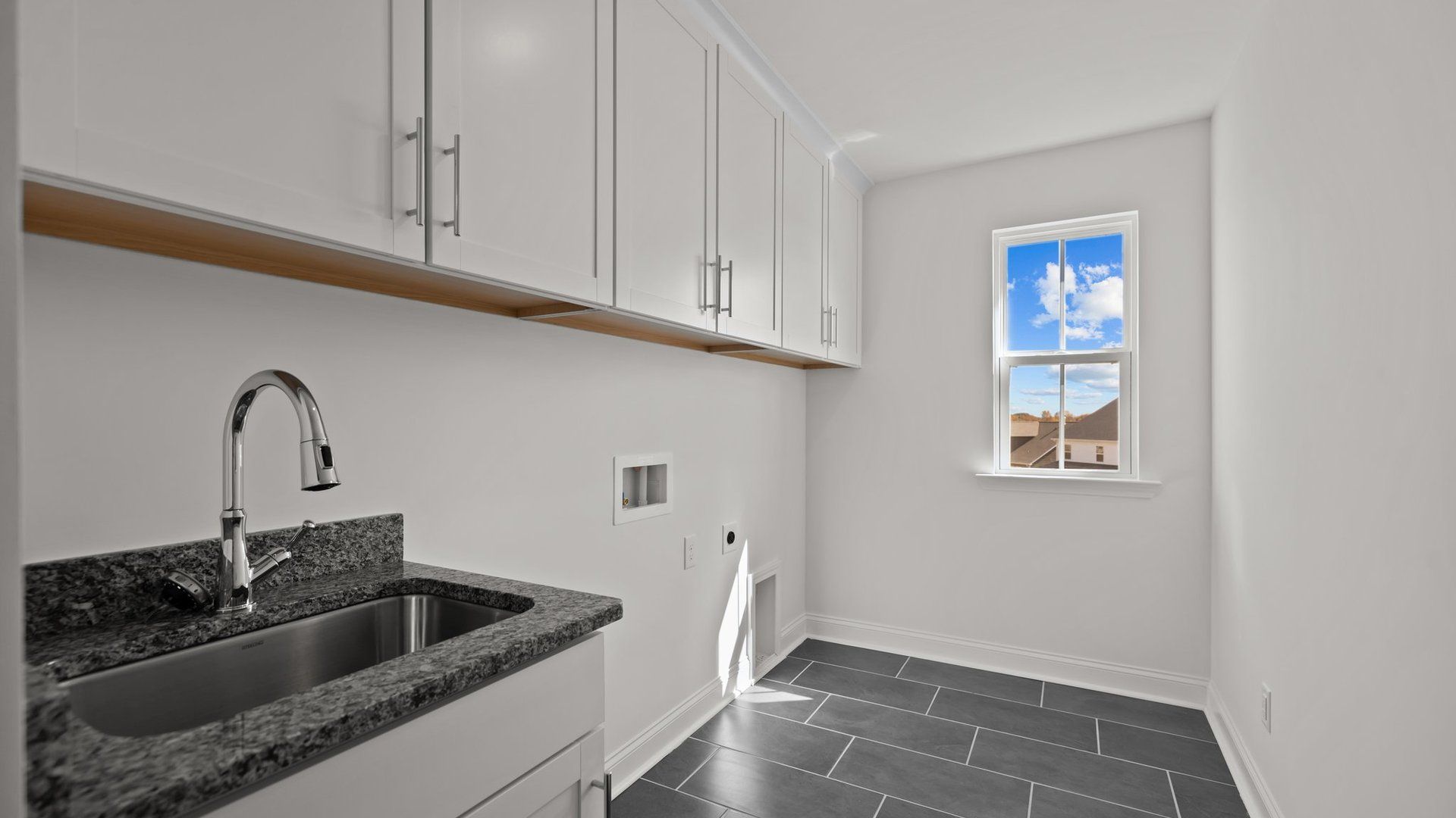 Burton Design laundry room with sink, extra cabinets, and premium finishes. By DRB Homes at Lakeside Glen in York, SC.