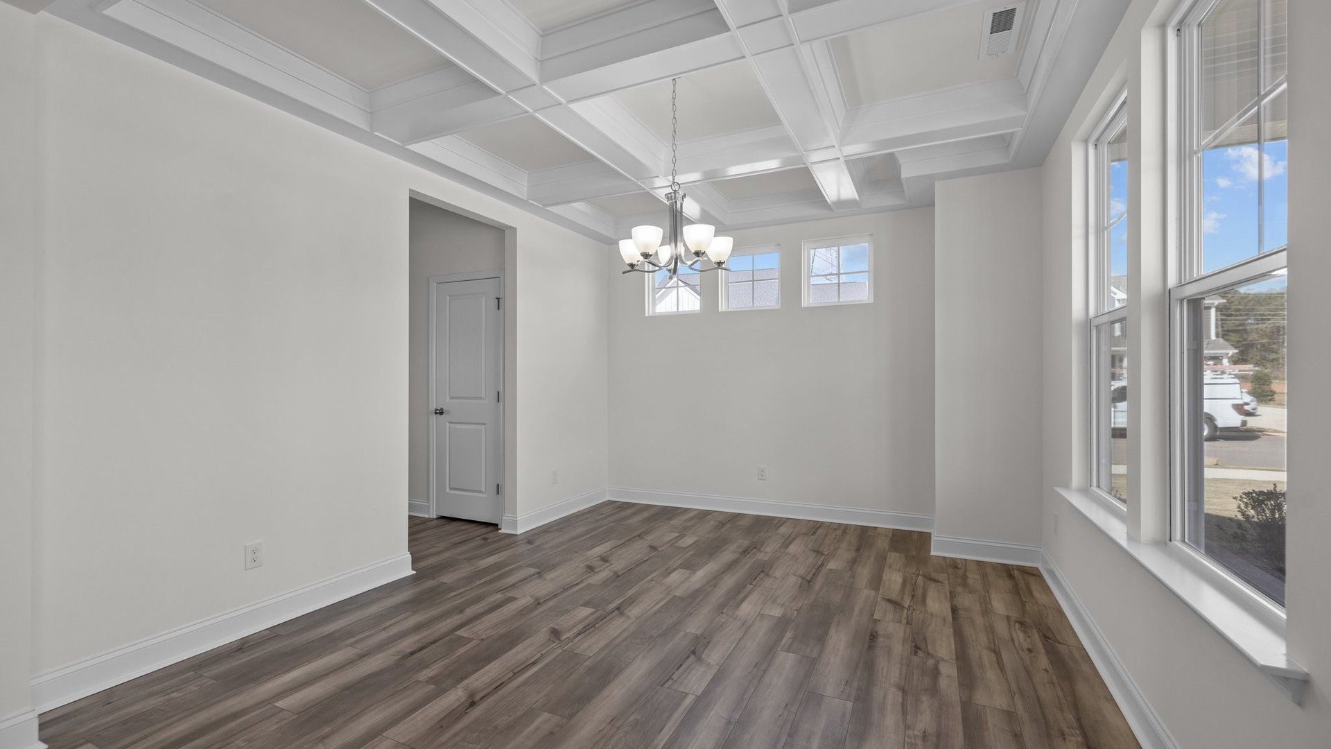 Fairfield design dining room with elevated coffered ceiling and large windows at Lakeside Glen by DRB Homes, York, SC.