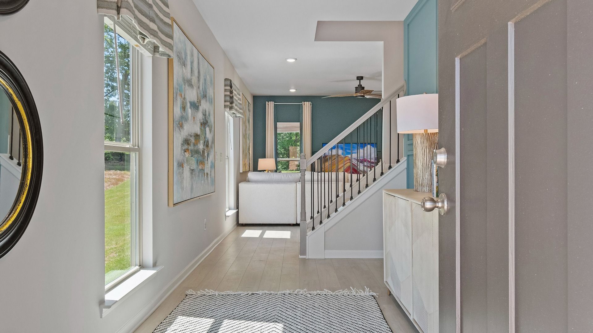 Reagan foyer with LVP flooring, natural light, and open hallway in Abbotts Crossing single family home in Conyers, GA.