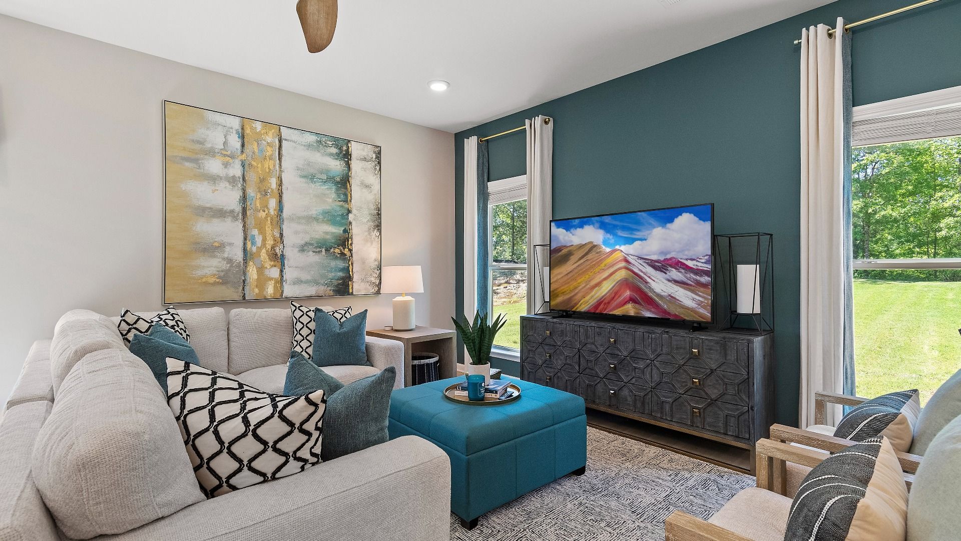 Reagan family room with comfortable seating area and large windows at Abbotts Crossing in Conyers, GA.