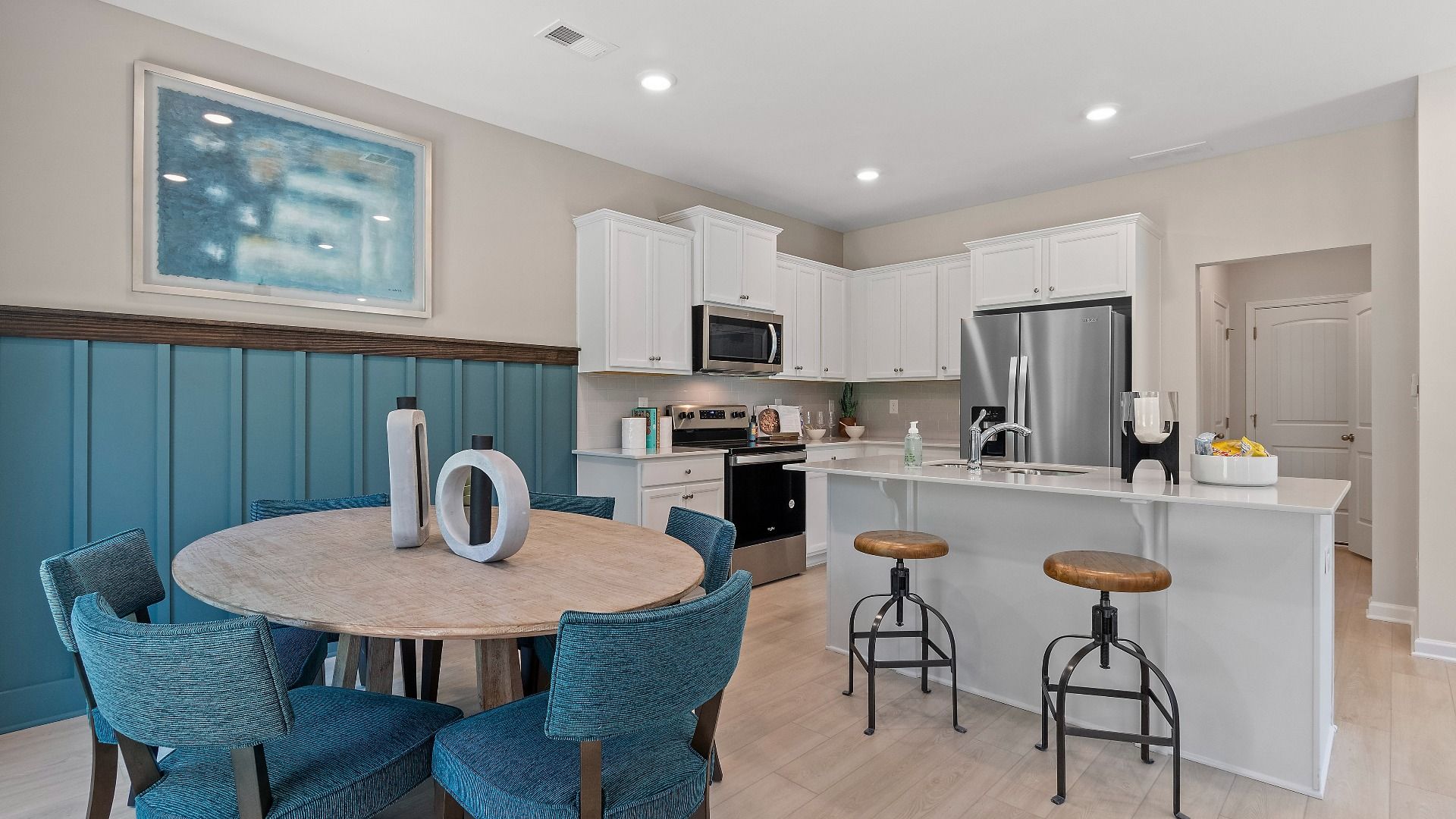 Open concept kitchen connecting to breakfast area featuring modern finishes and comfortable seating room at Abbotts Crossing.