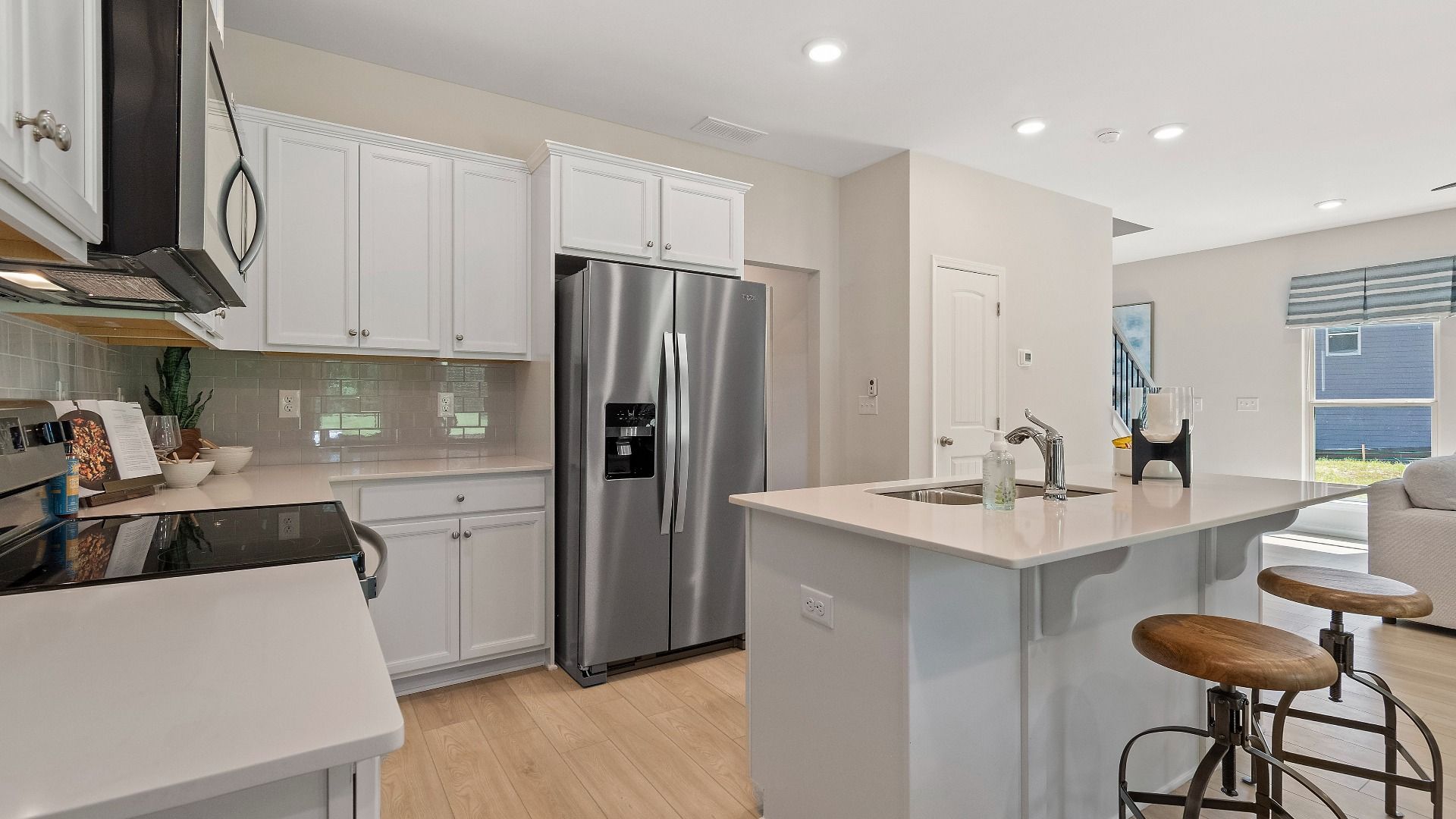 Reagan kitchen with stainless appliances, white cabinetry, and center island at Abbotts Crossing.