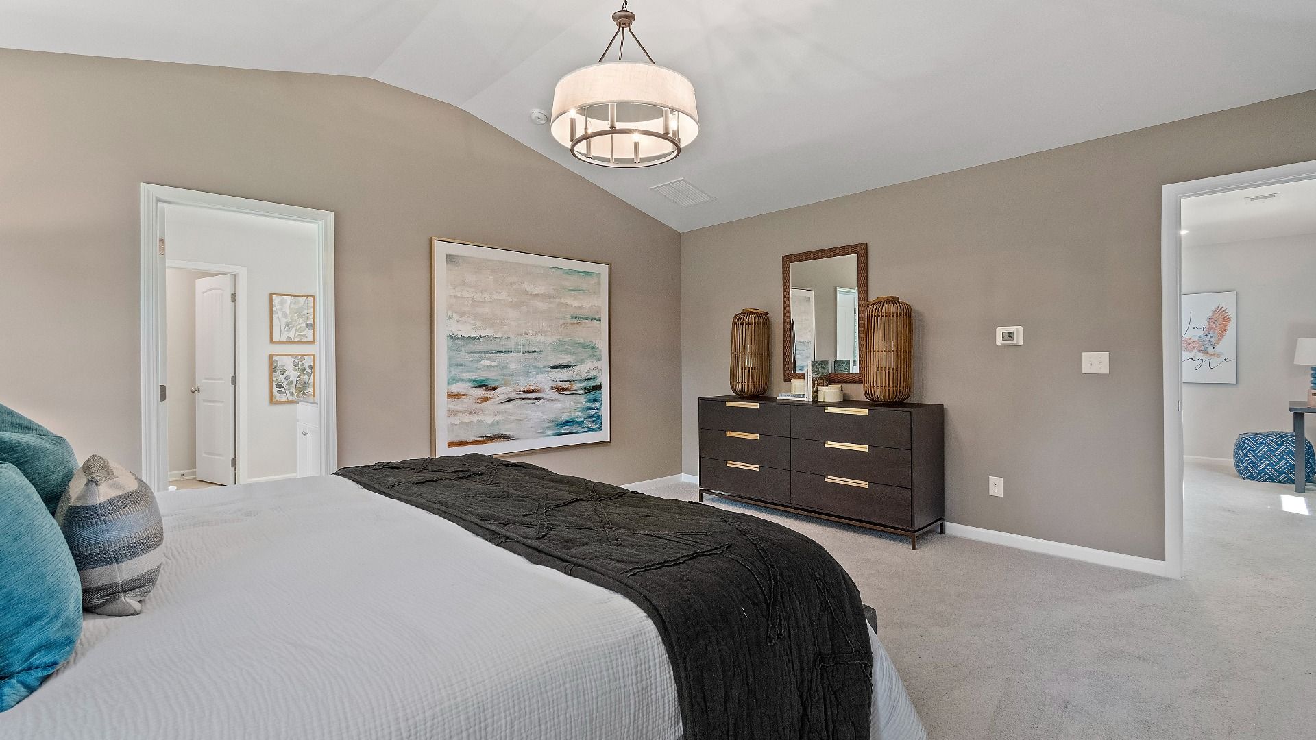 Reagan spacious primary suite with carpet flooring and connecting primary bath at Abbotts Crossing in Conyers, GA.
