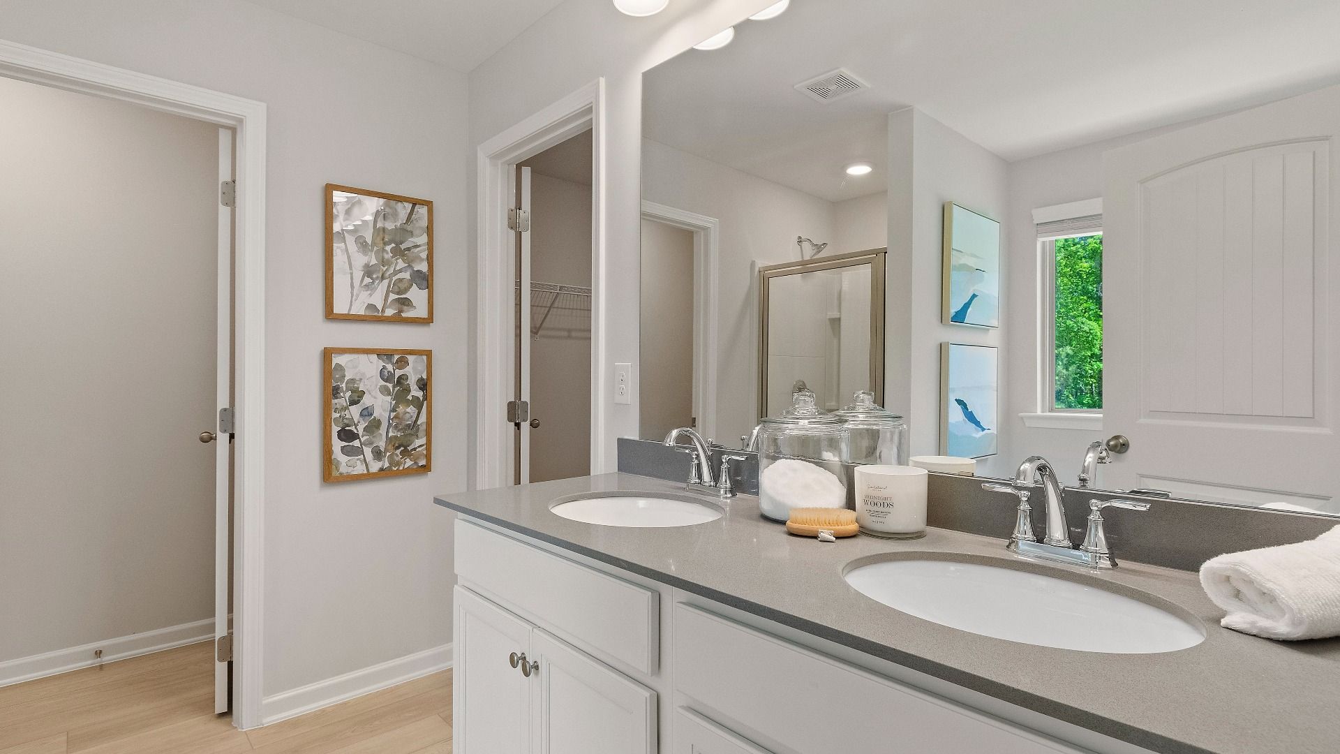 Primary suite bath with dual vanities and LVP flooring at Abbotts Crossing in Reagan floorplan.