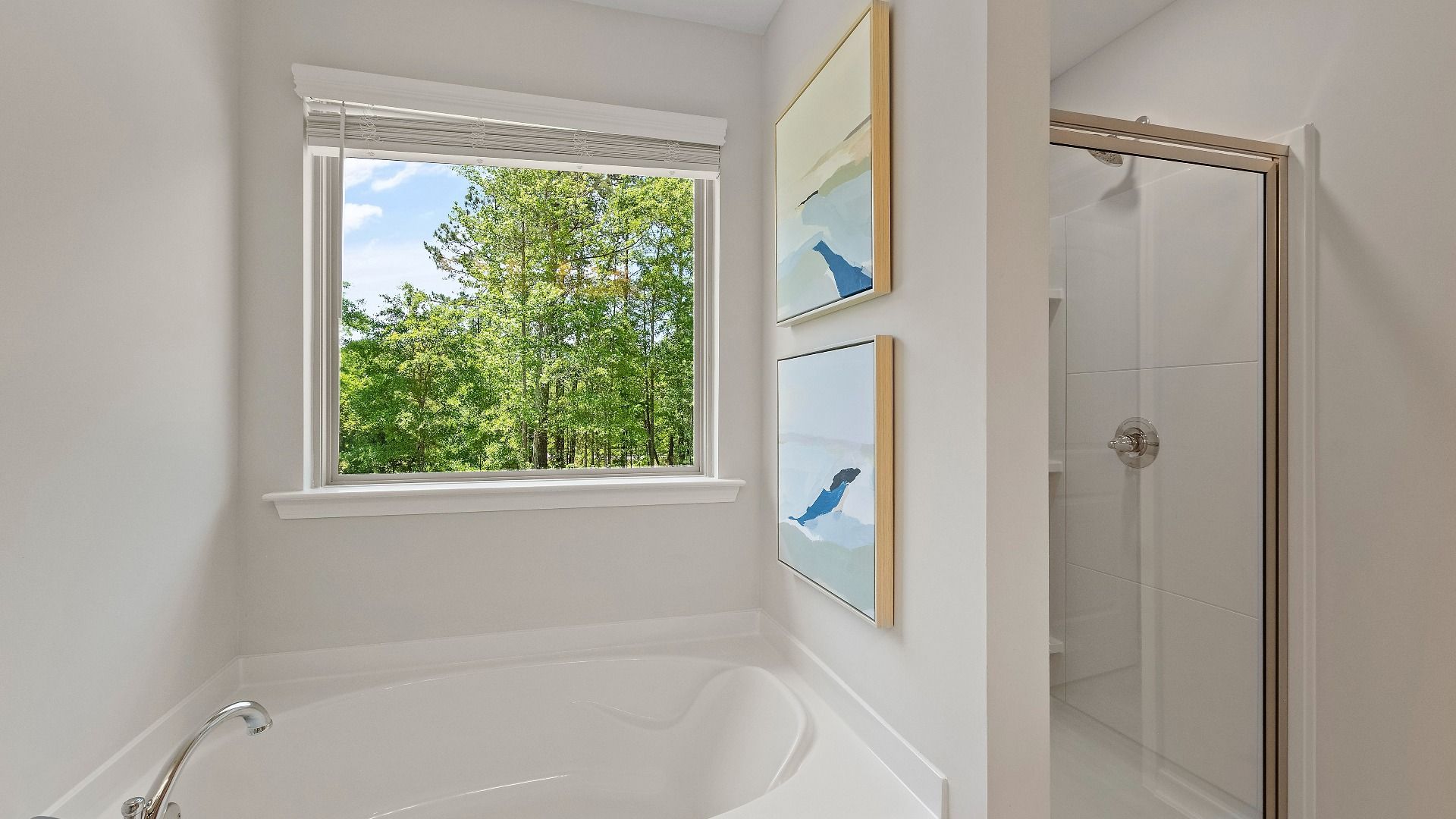 Reagan primary suite bath featuring walk in shower and separate tub with window at Abbotts Crossing.