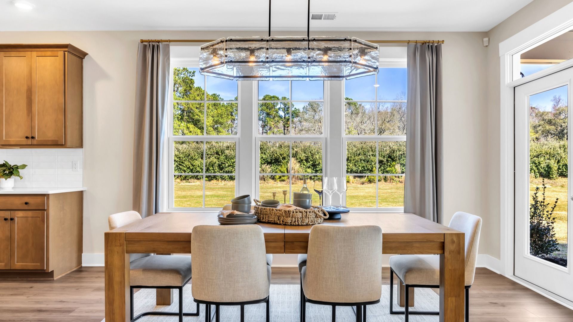 Open concept dining room in Chestnut Farms in by DRB homes offering wood floors and lots of natural light