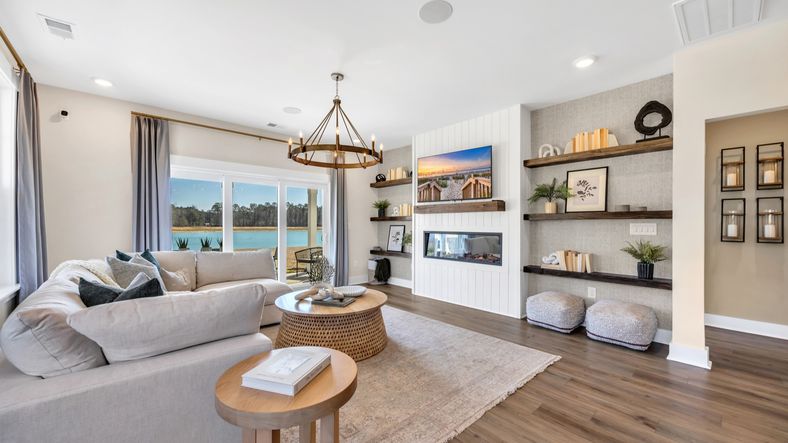 Open concept living room in Chestnut Farms in by DRB homes offering lots of seating and a cozy environment