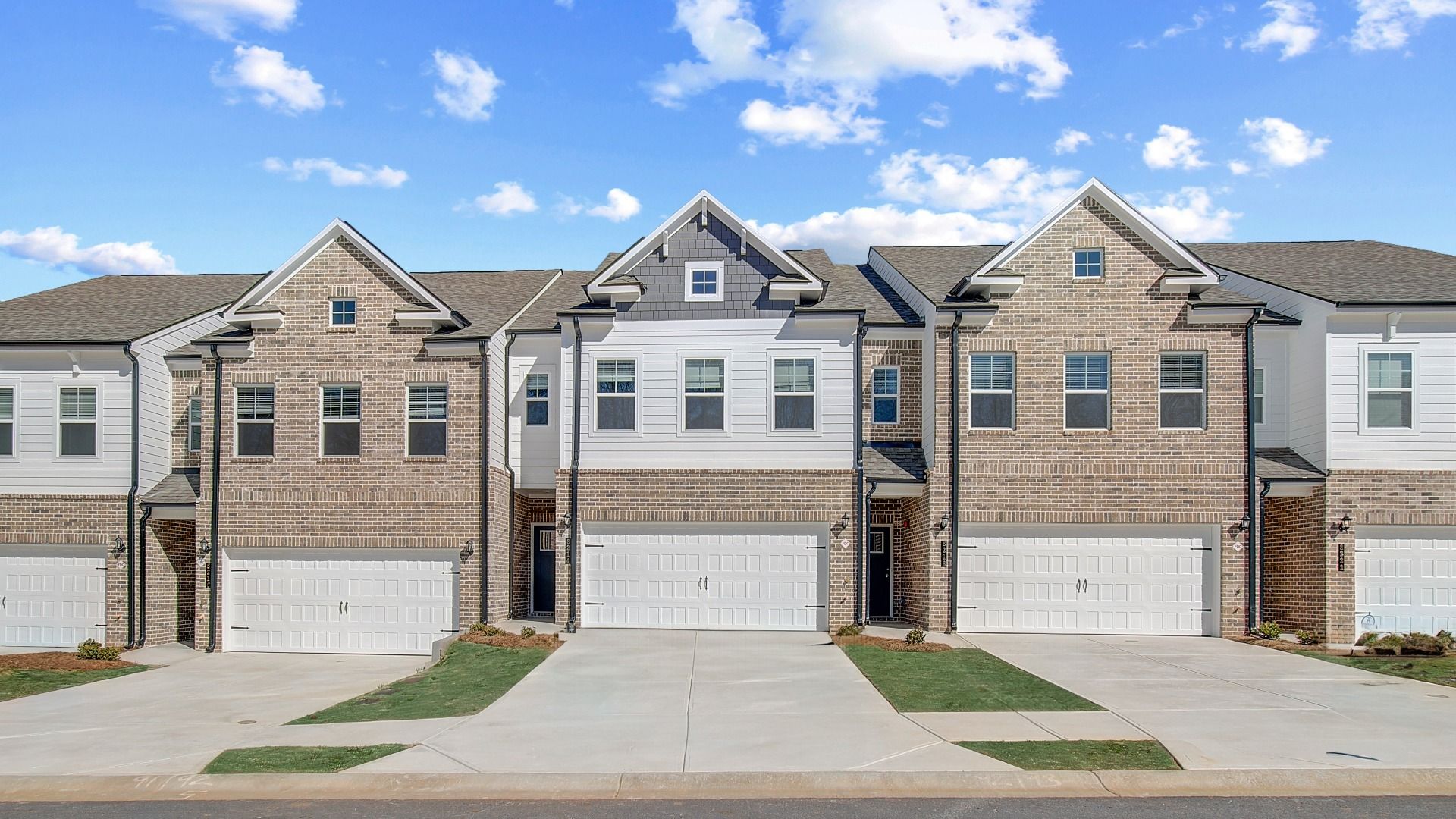 Row of new construction townhomes with brick exteriors and curb appeal in Auburn Ridge community in Riverdale, GA.