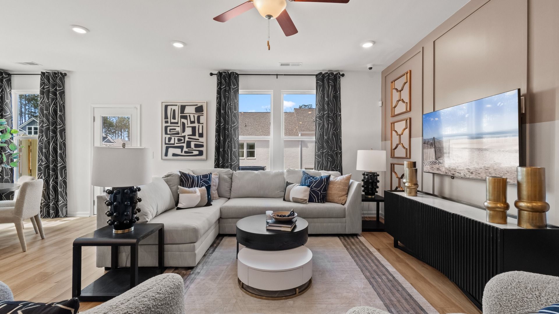 Bright open Austin Alternate family room with LVP flooring and flow into kitchen and breakfast area at Bowers Farm Townhomes.