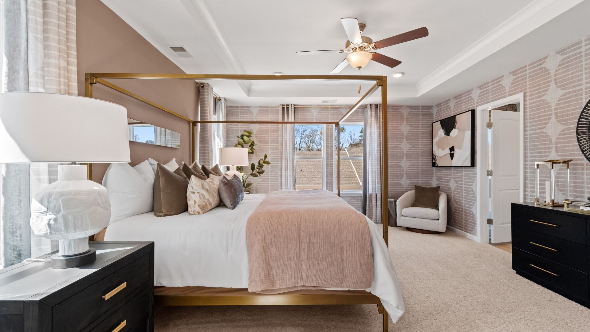 Bright primary suite with tray ceiling, carpet flooring, and connected bath in the Austin Alternate at Bowers Farm Townhomes.