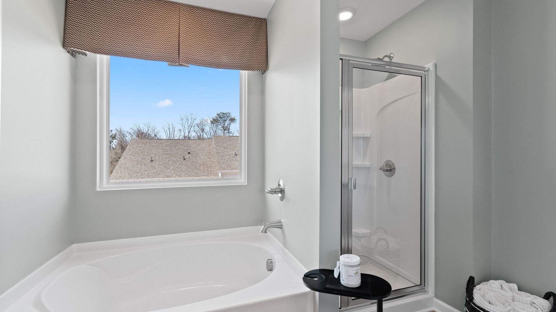 Primary bath with standalone tub, walk-in shower, and natural light in the Austin Alternate at Bowers Farm Townhomes.
