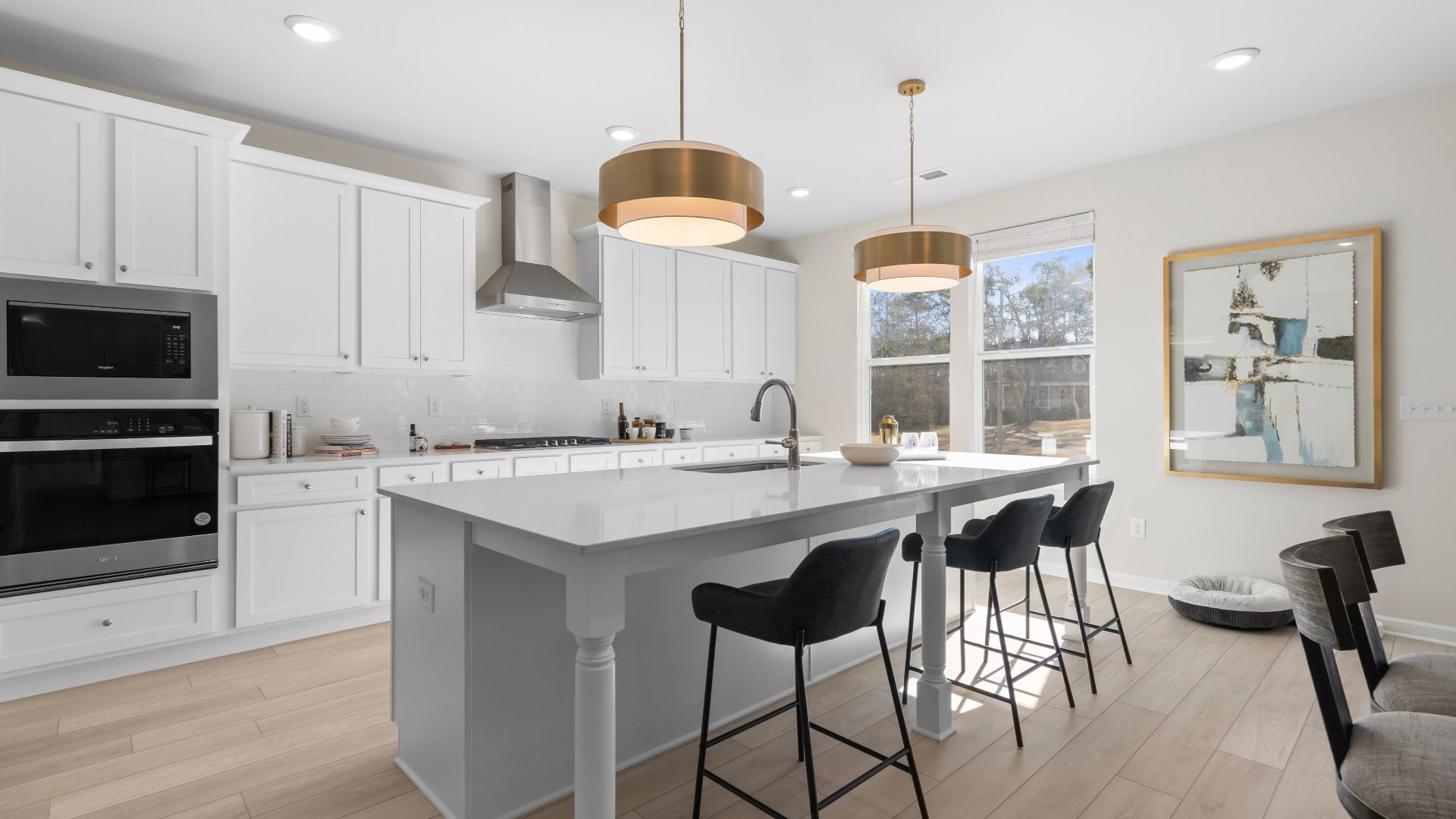 Ridgewood bright modern kitchen with white cabinetry, tile backsplash, and large island with seating at Burchwood.