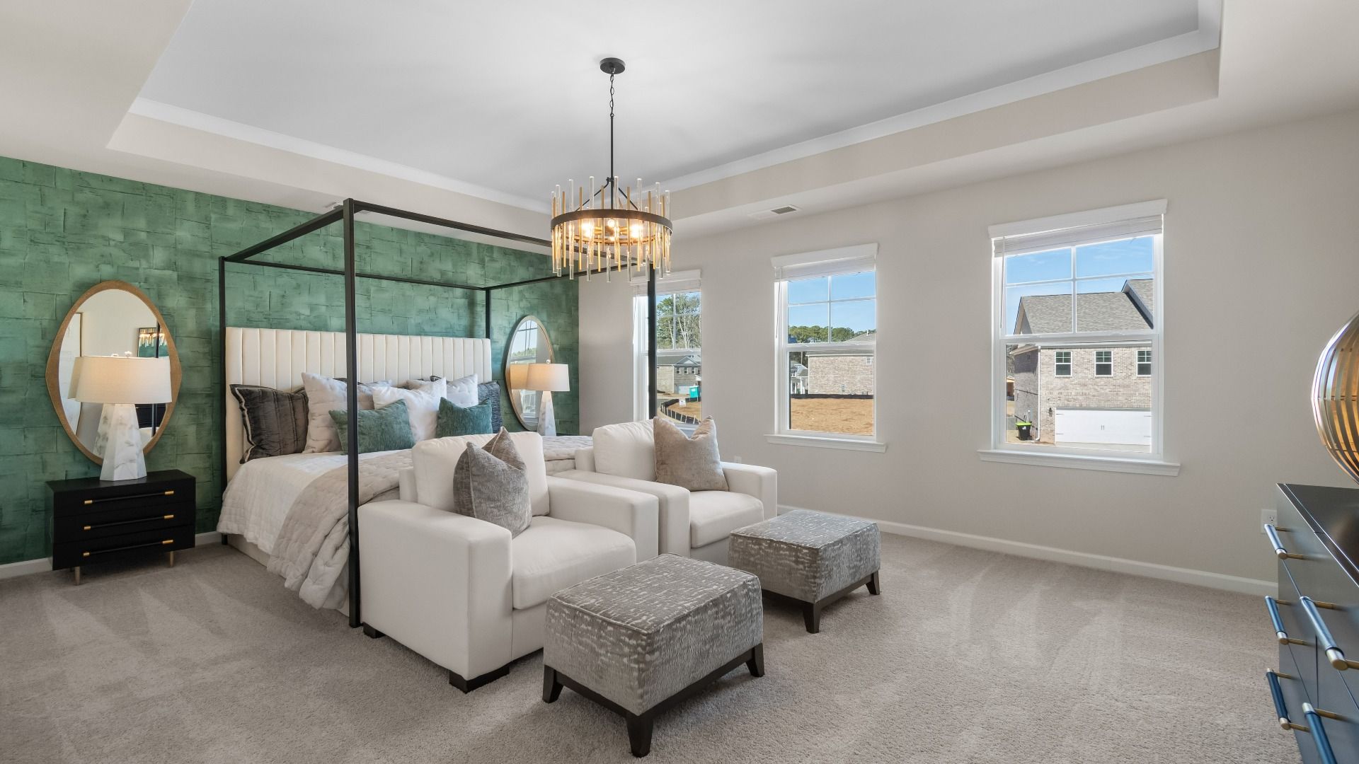 Ridgewood spacious primary suite with tray ceiling, carpet flooring, and seating area at Burchwood in Stockbridge, GA.