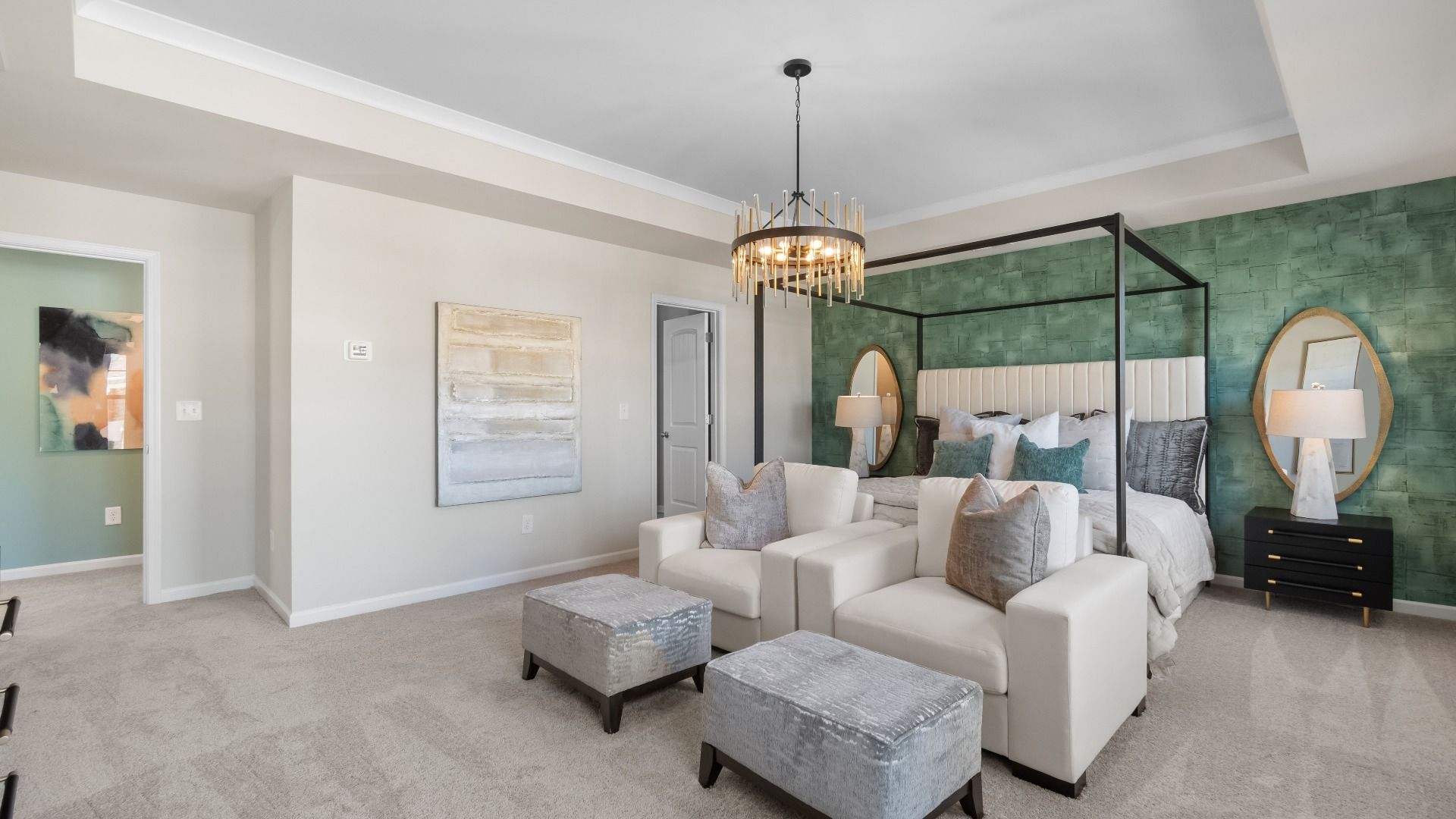 Ridgewood spacious primary suite with tray ceiling, carpet flooring, and seating area at Burchwood in Stockbridge, GA.