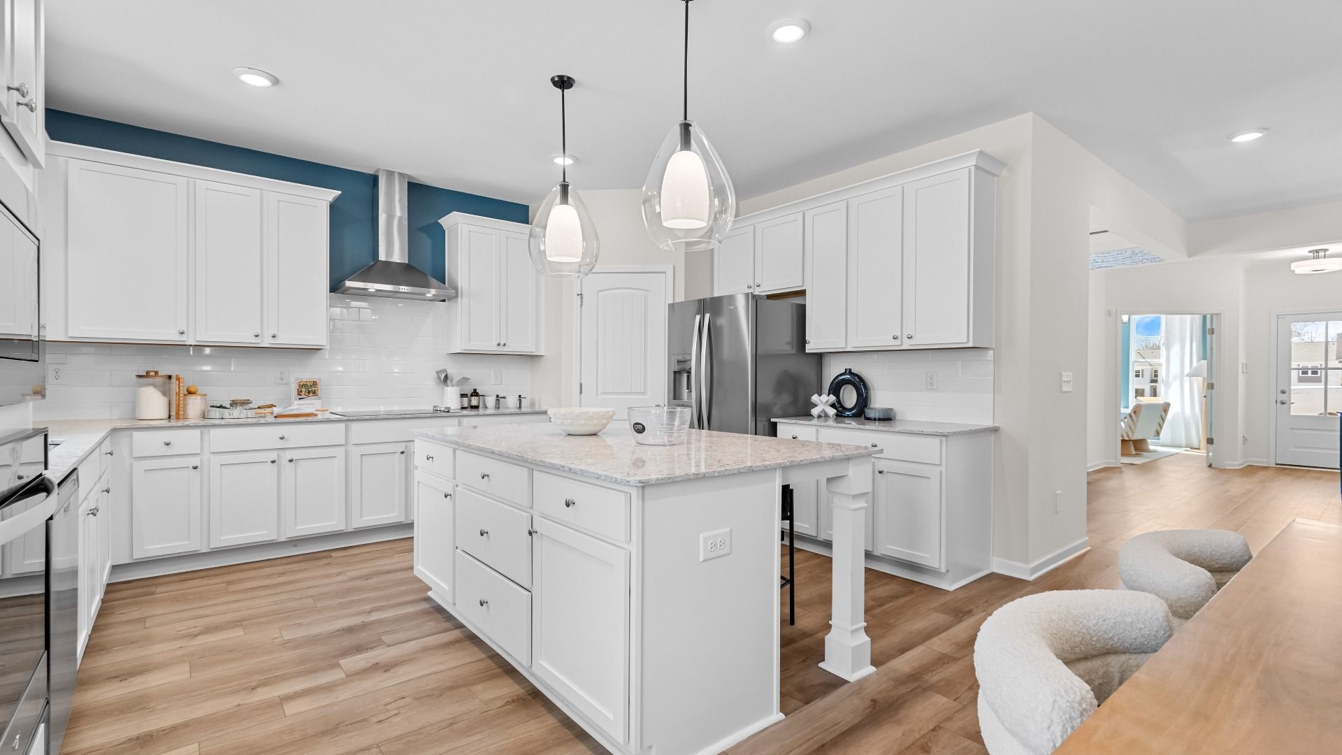 Spacious Wynwood kitchen with modern white tile backsplash, white cabinetry, and stainless appliances at Bowers Farm.