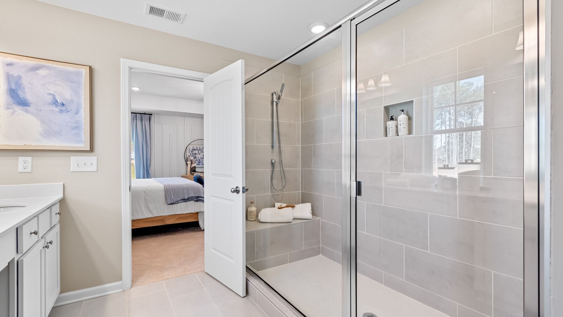 Wynwood primary bath with oversized walk-in shower, tile floors, and white modern design at Bowers Farm in McDonough, GA.