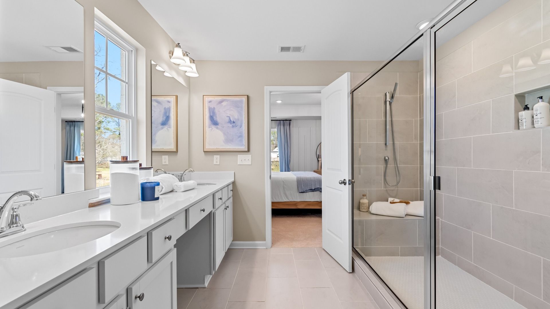 Bright Wynwood primary bath with dual vanities, tile floors, and neutral modern design at Bowers Farm in McDonough, GA.