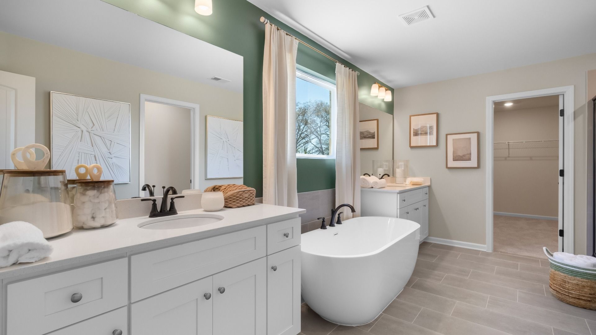 Primary bathroom with freestanding soaking tub, double vanity, and walk-in closet at Cambria at Traditions in Hampton, GA.