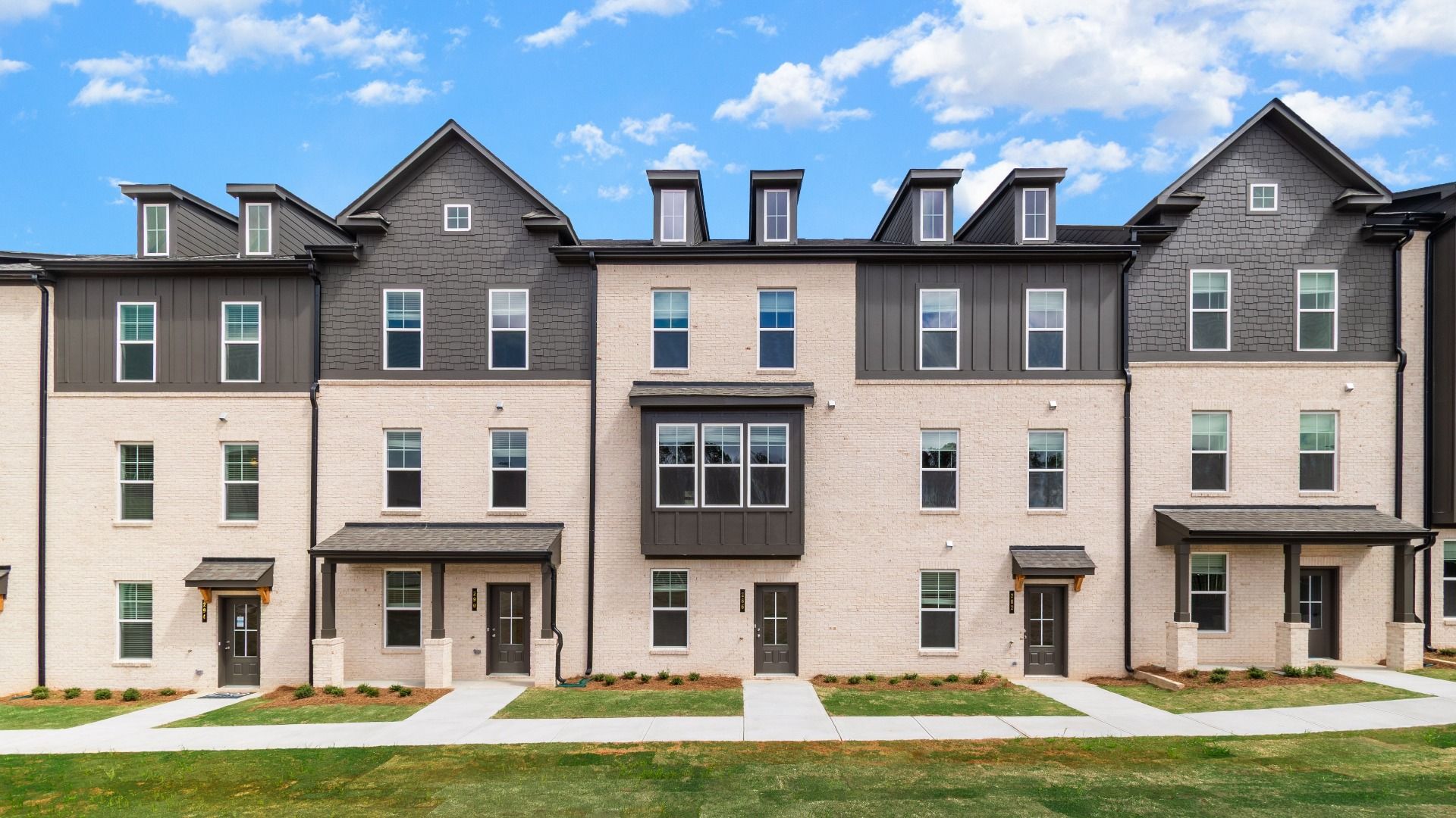 Three-story luxury new construction townhomes with brick and siding exterior features at Daybreak in Newnan, GA.