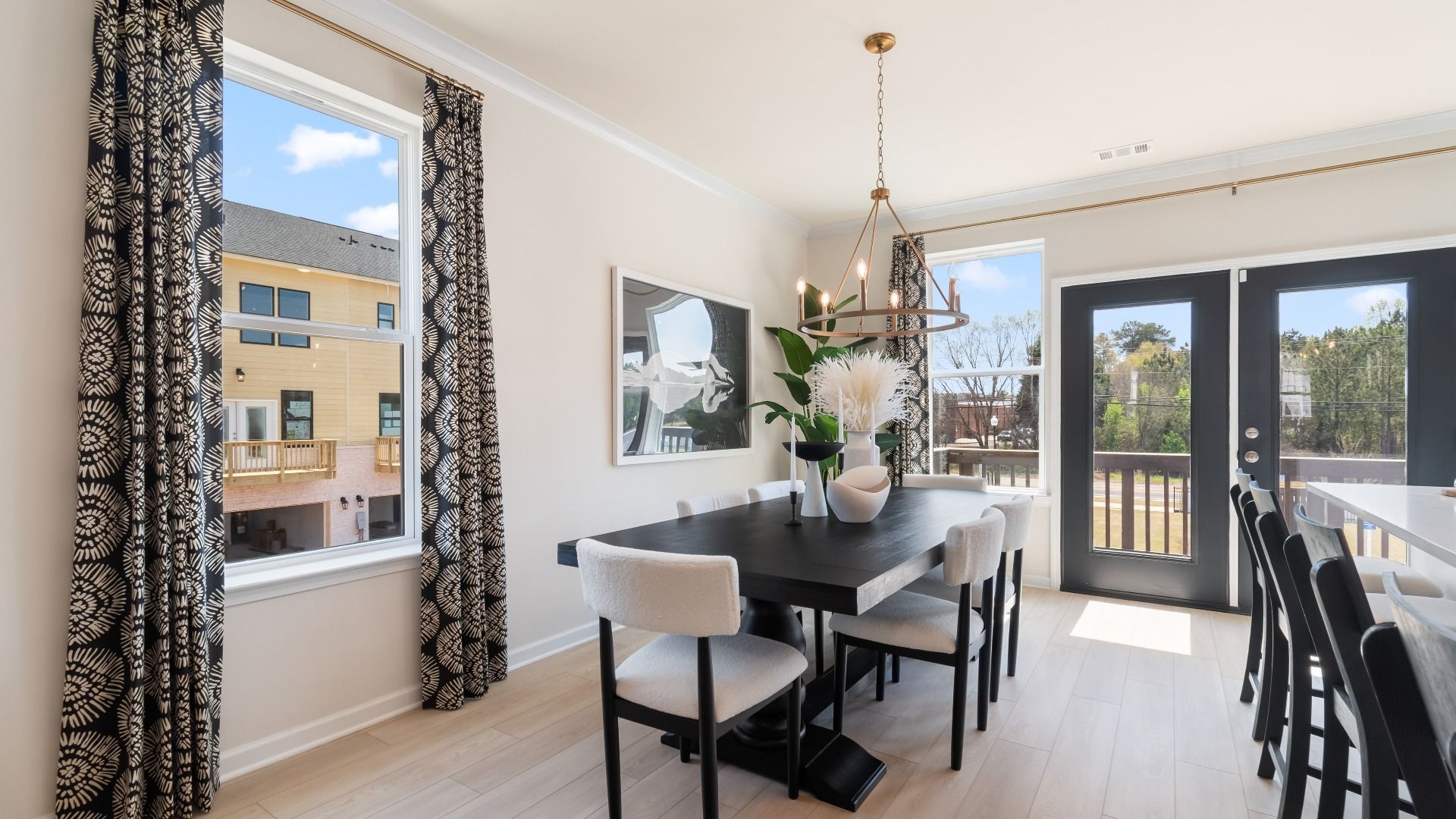Naturally lit comfortable breakfast area with neutral finishes and view of balcony at Silverock in McDonough, GA.