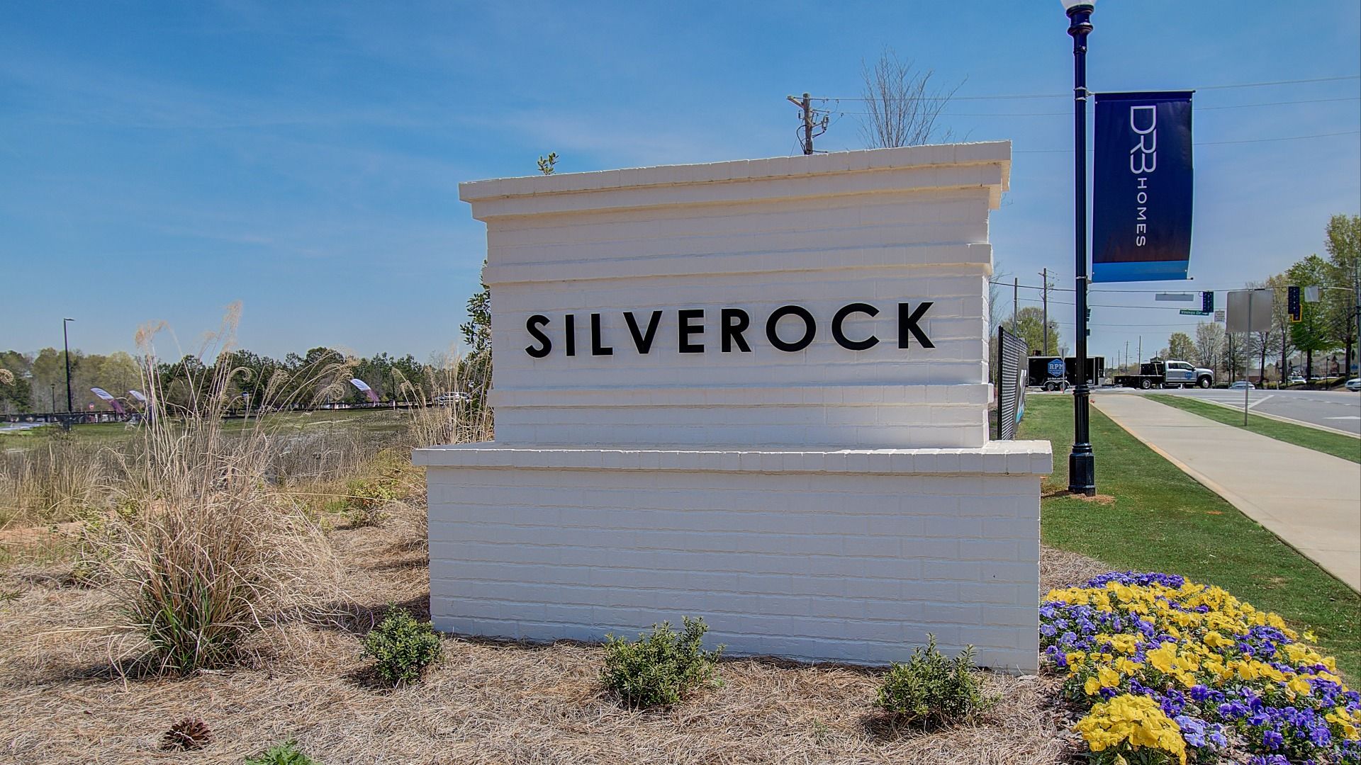 Welcoming white entrance monument to new construction townhome Silverock Community.