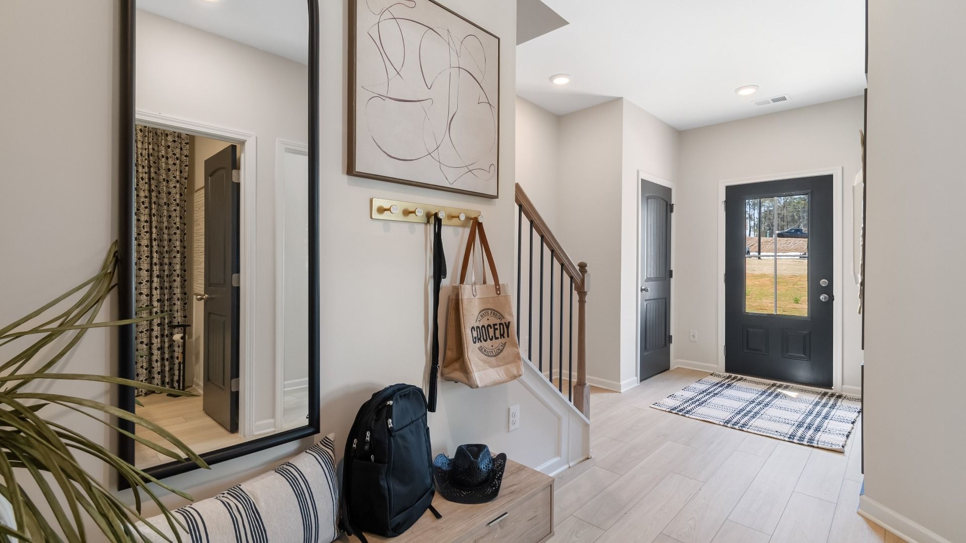 Interior entry with staircase, side closet, and drop zone for storage at Daybreak in Newnan, GA.