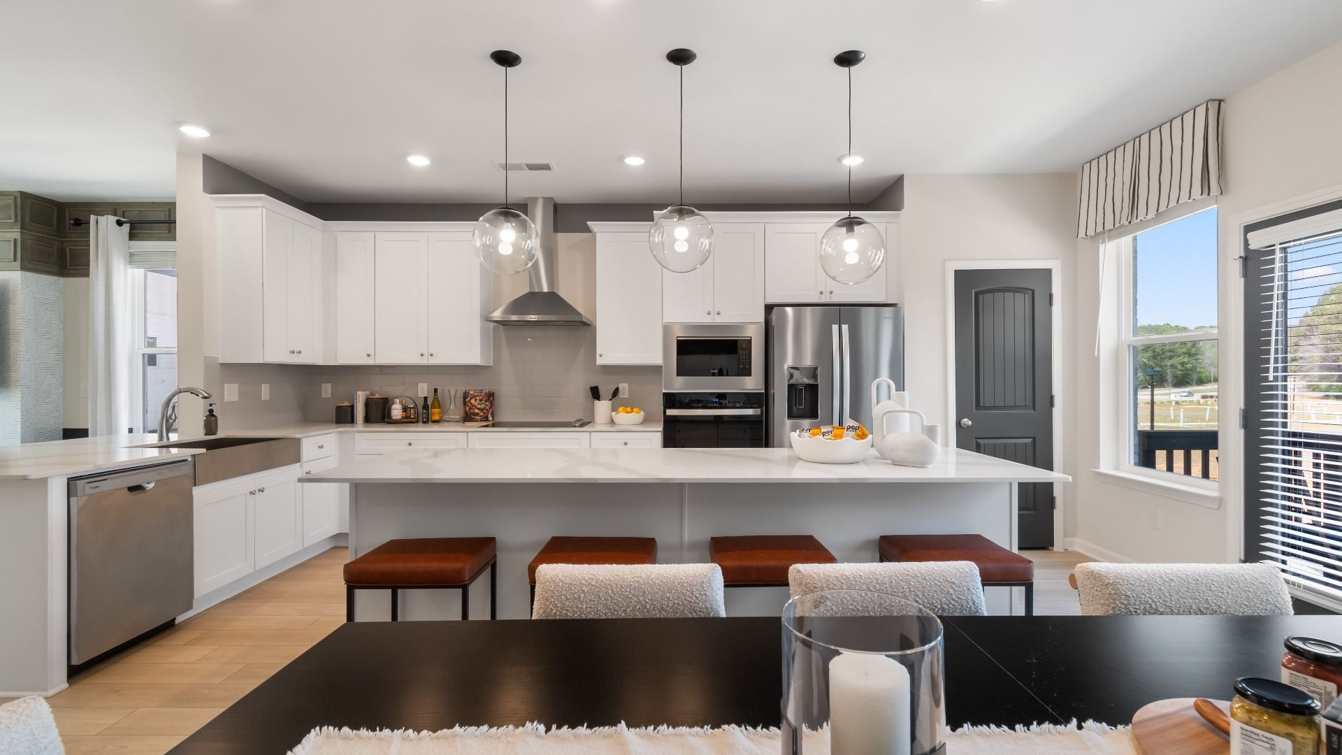 Modern kitchen featuring large island with seating, stainless steel appliances, and pendant lighting at Daybreak.