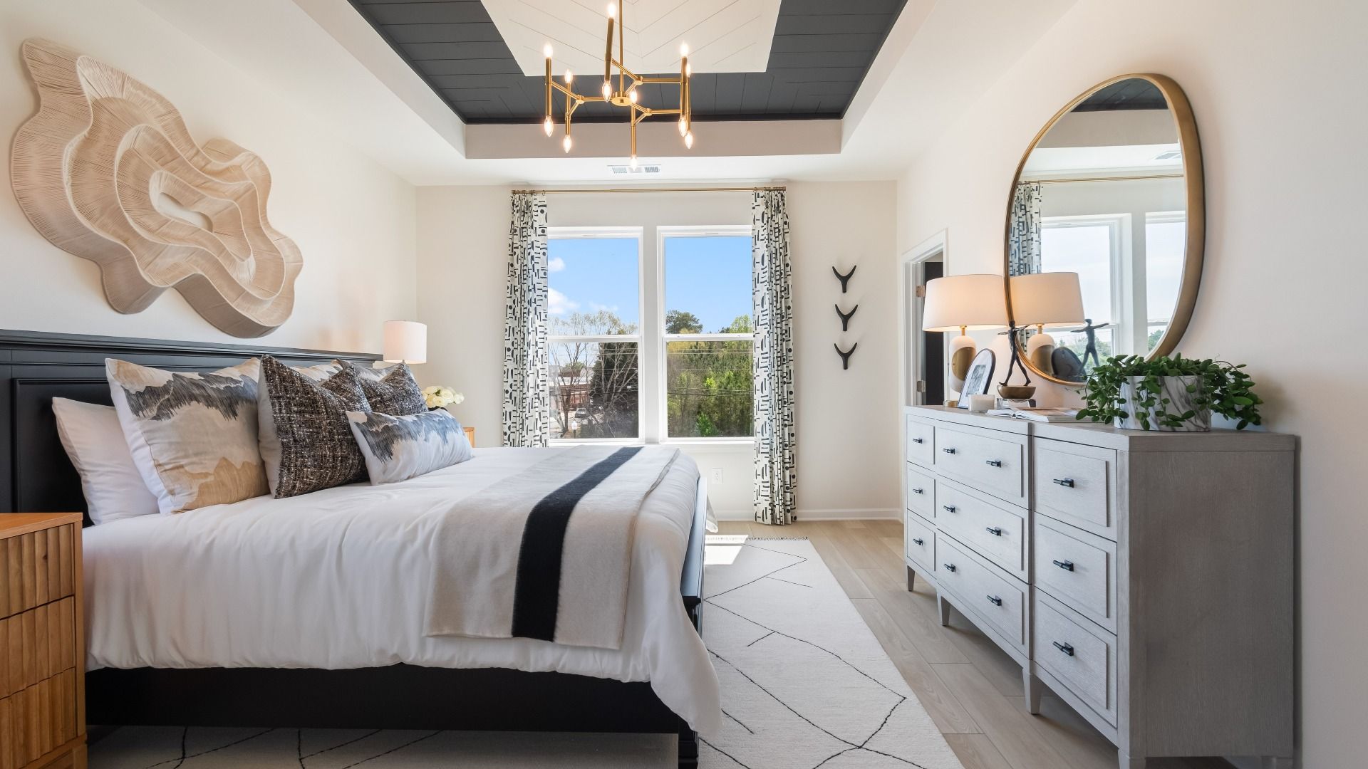 Luxury primary suite with tray ceiling and large windows for spacious feel at new construction townhome at Silverock.