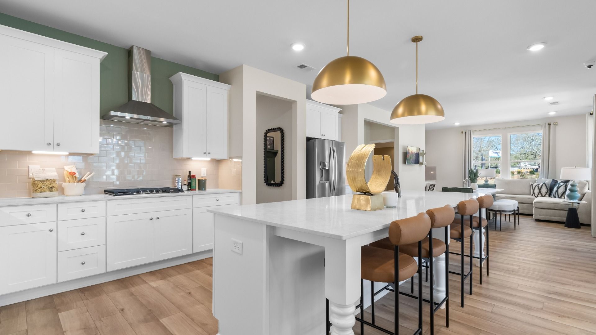 Bright kitchen with white cabinetry, large island, and modern pendant lighting at The Park at Brighton in Locust Grove, GA.