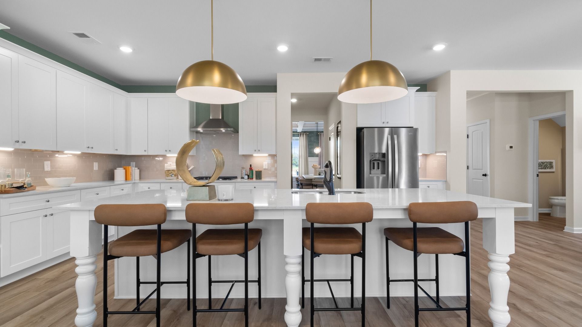 Modern open-concept kitchen with stainless appliances and island seating at The Park at Brighton in Locust Grove, GA.