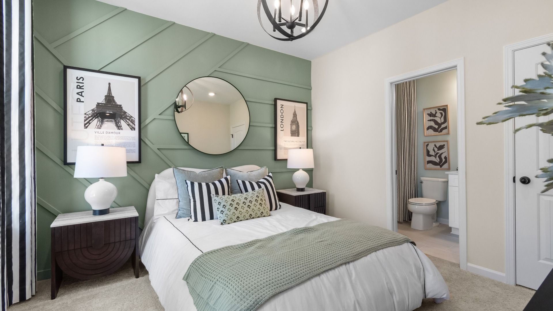 Secondary bedroom with carpet flooring, large window, and connecting bath at The Park at Brighton in Locust Grove, GA.