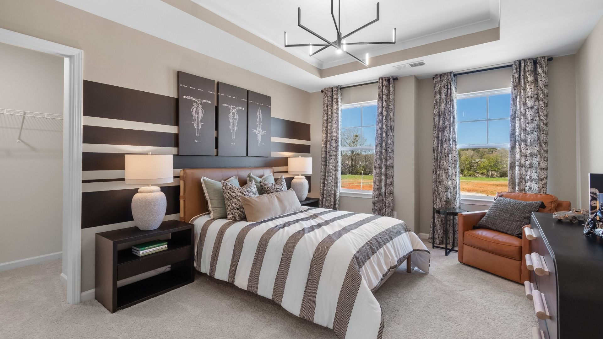 Secondary bedroom featuring tray ceiling, large windows, and walk-in closet at The Park at Brighton in Locust Grove, GA.