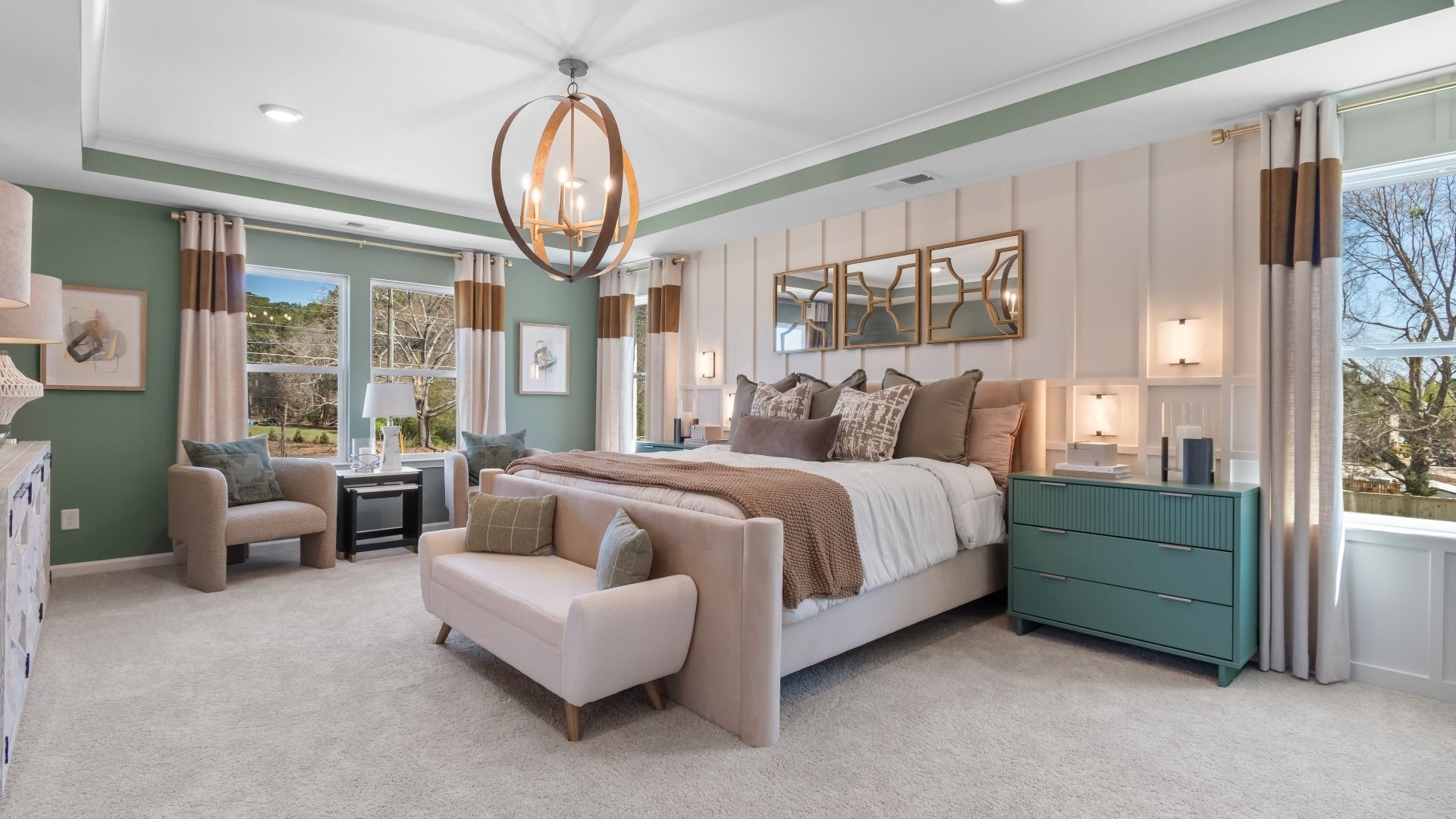 Luxury primary suite featuring comfortable sitting area and tray ceiling at The Park at Brighton in Locust Grove, GA.