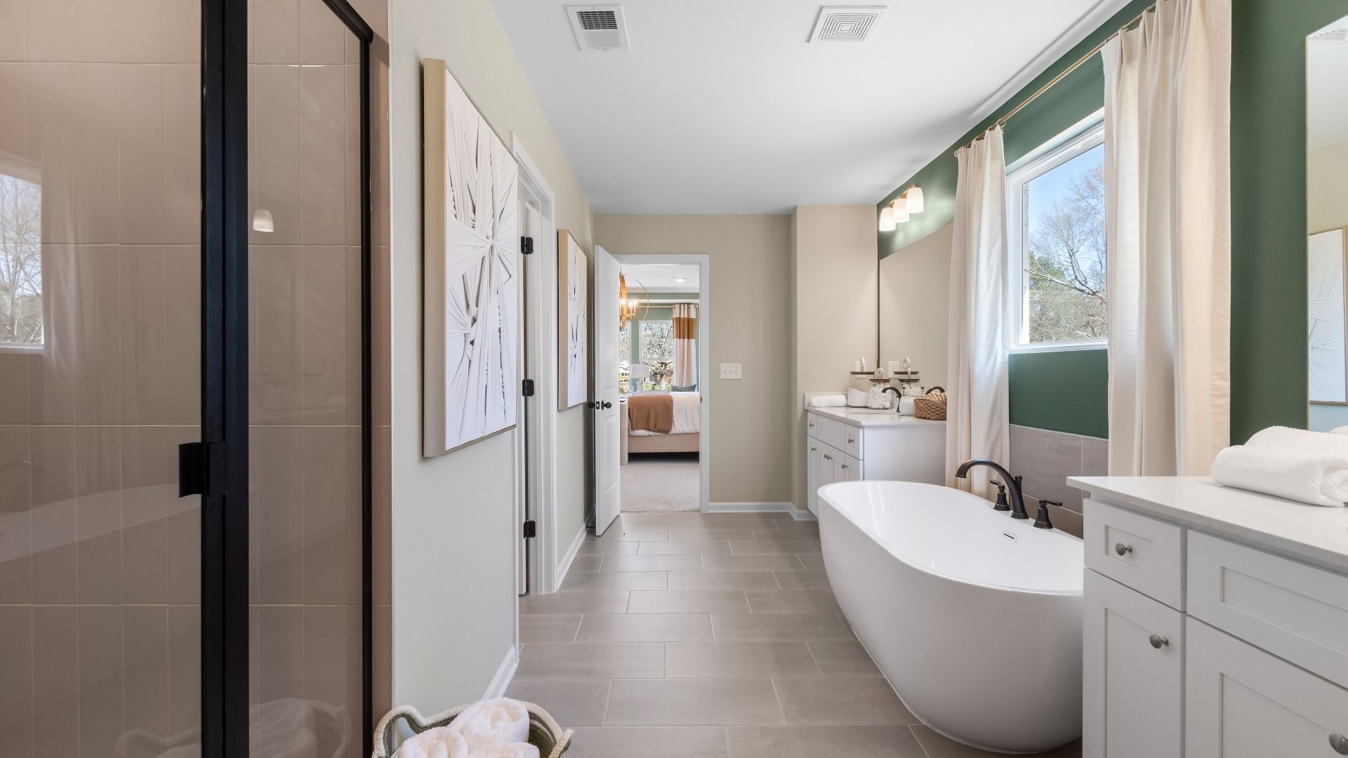 Spa-like primary bath with freestanding tub, doble vanity, and tile features at The Park at Brighton in Locust Grove, GA.