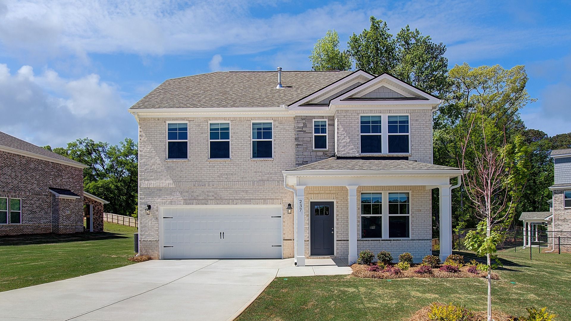 Pelham new construction single-family home with brick-dominant exterior and two-car front-entry garage at Burchwood.