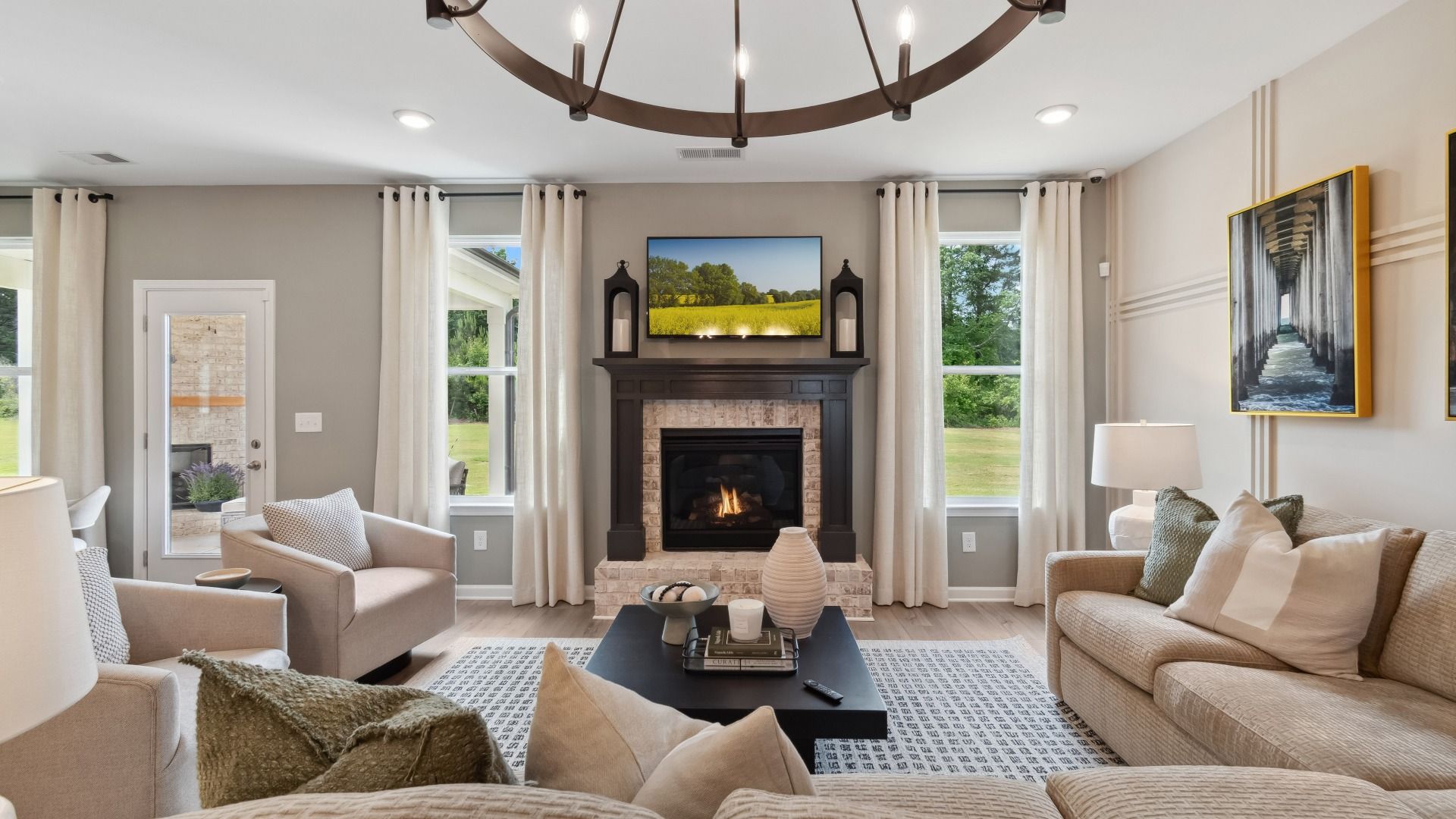 Luxury modern family room with LVP flooring and gas fireplace with brick surround at Westwind Estates in Hampton, GA.
