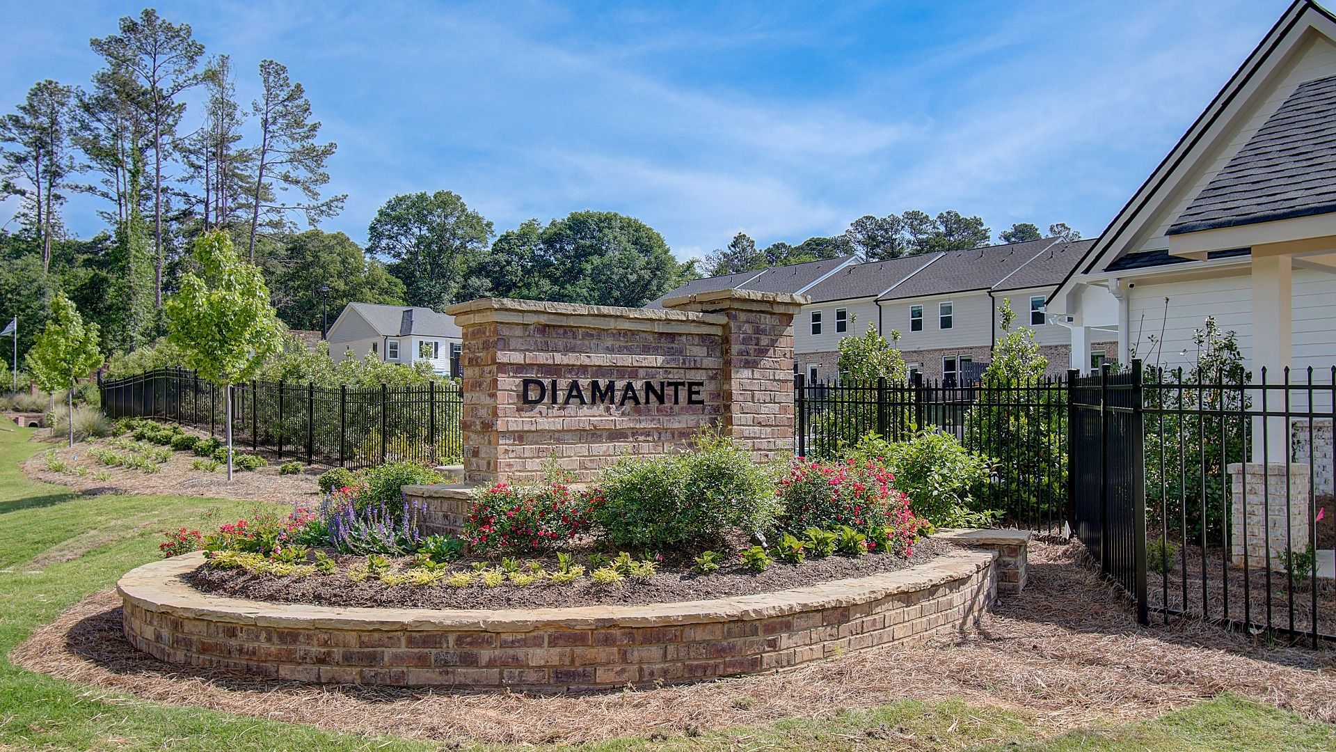 Welcome sign at the landscaped entrance to Diamante townhome community in Stockbridge, GA.