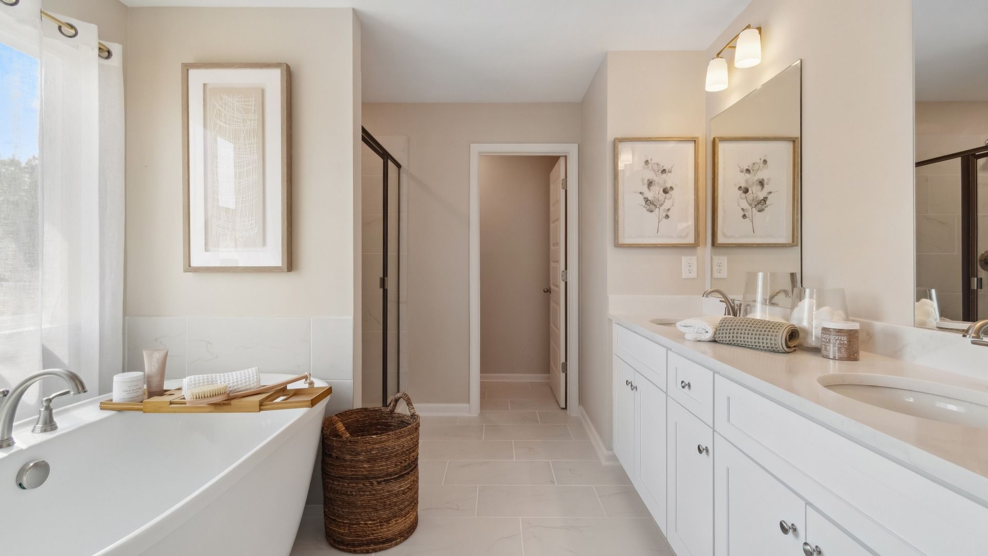 Luxury primary bath with tile flooring, freestanding tub and dual vanities at Westwind Estates in Hampton, GA.