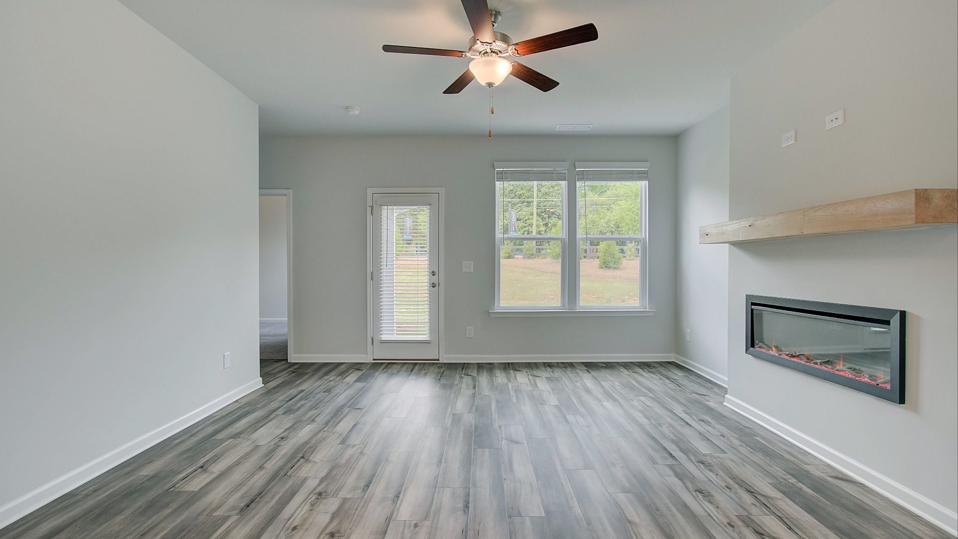 Inviting family room featuring LVP flooring and electric fireplace with mantel