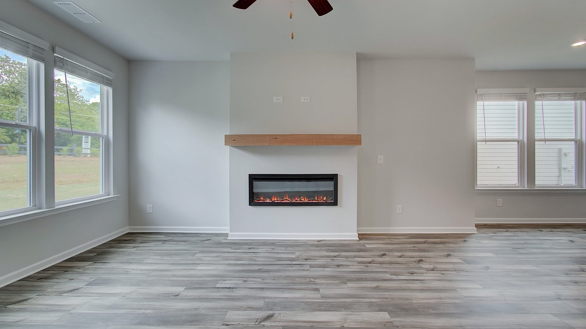 Inviting family room featuring LVP flooring and electric fireplace with mantel