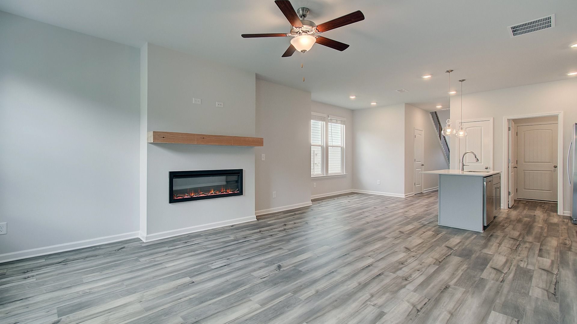 Inviting family room featuring LVP flooring and electric fireplace with mantel
