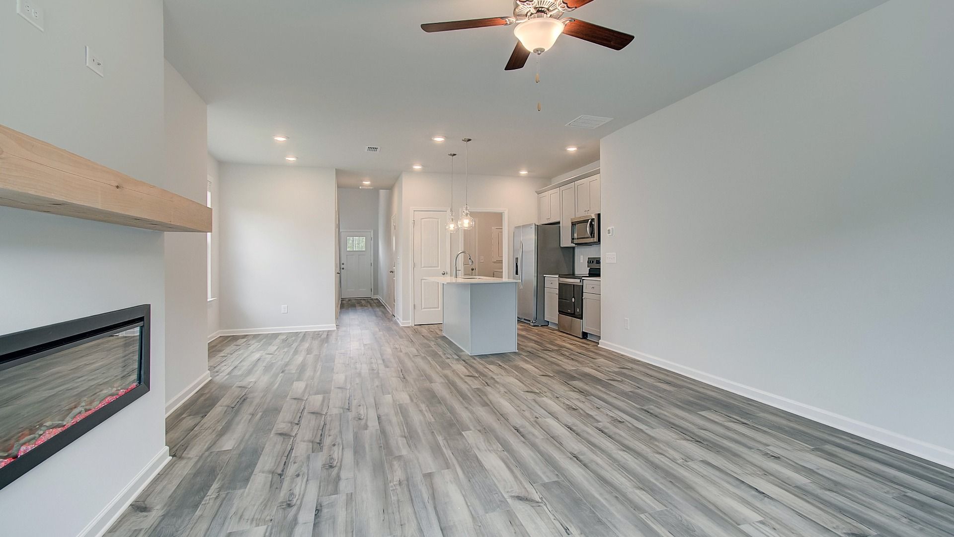 Inviting family room featuring LVP flooring and electric fireplace with mantel