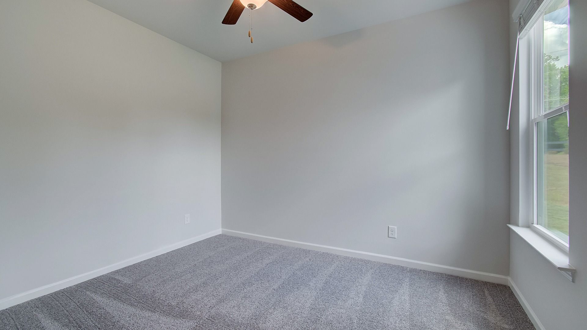 Generously sized bedroom with abundant daylight from expansive windows.