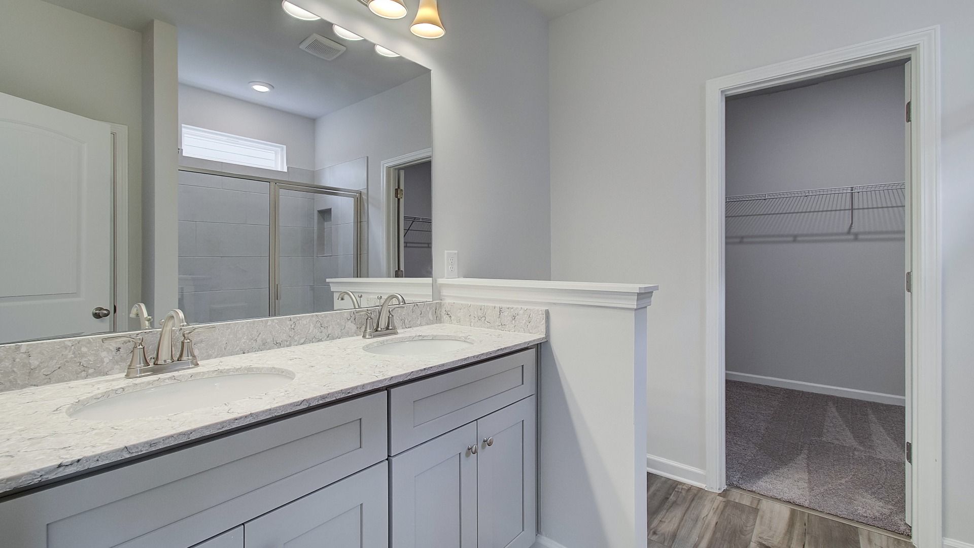 Primary bathroom vanity featuring undermount sinks, sleek faucets, and quartz countertops.