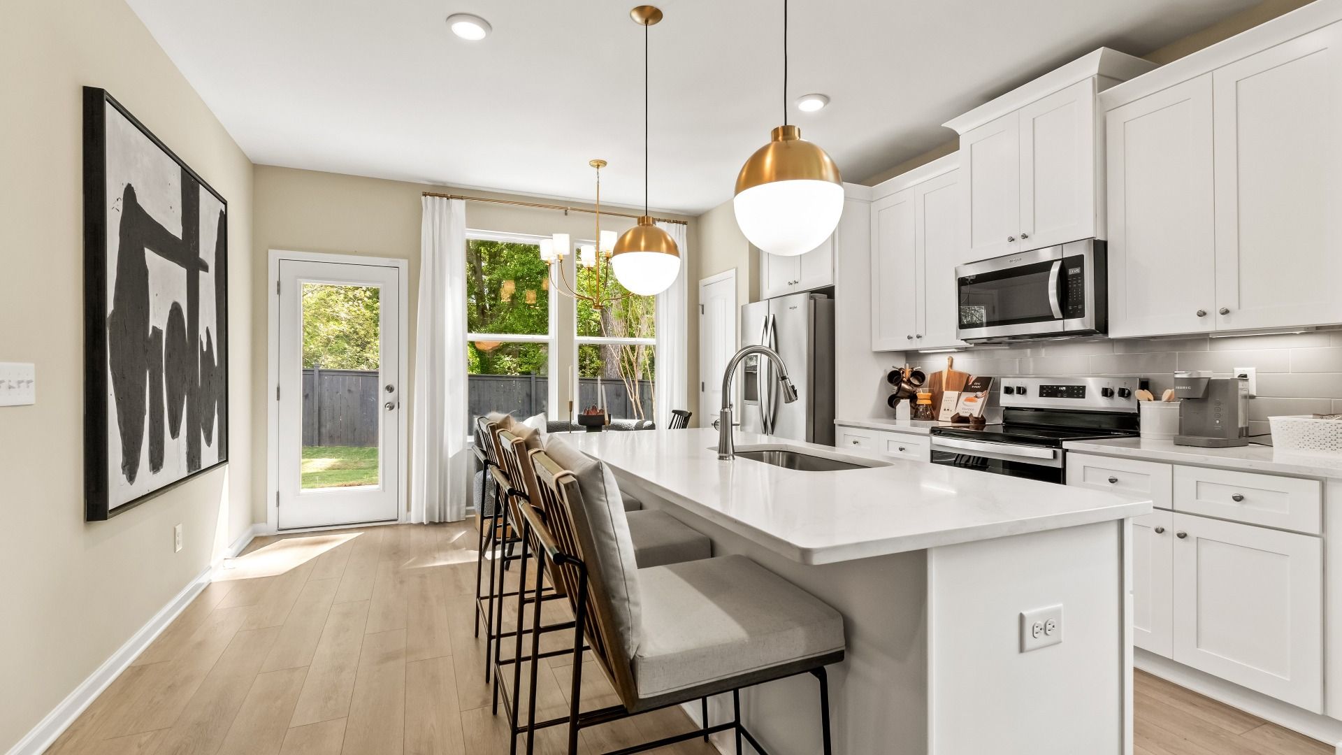New construction kitchen with large island, stainless steel appliances, and pendant lighting at Enclave at Evergreen.