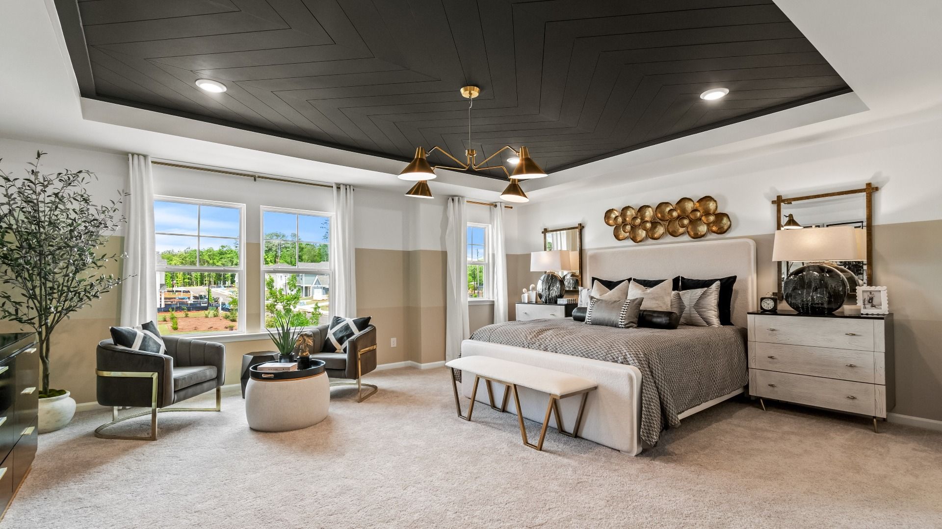 Upstairs primary suite featuring spacious layout with sitting area and large windows at Enclave at Evergreen in Fairburn, GA.