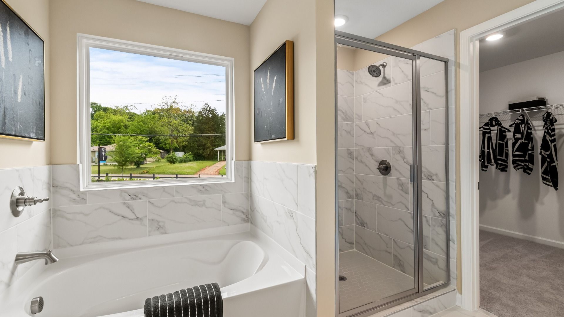 Elegant primary bathroom with soaking tub and walk-in shower featuring tile details at Enclave at Evergreen in Fairburn, GA.