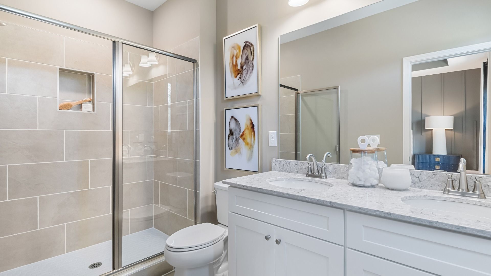 Elegant primary bath with walk-in shower featuring tile walls, dual vanity, and neutral designs at Daybreak in Newnan, GA.